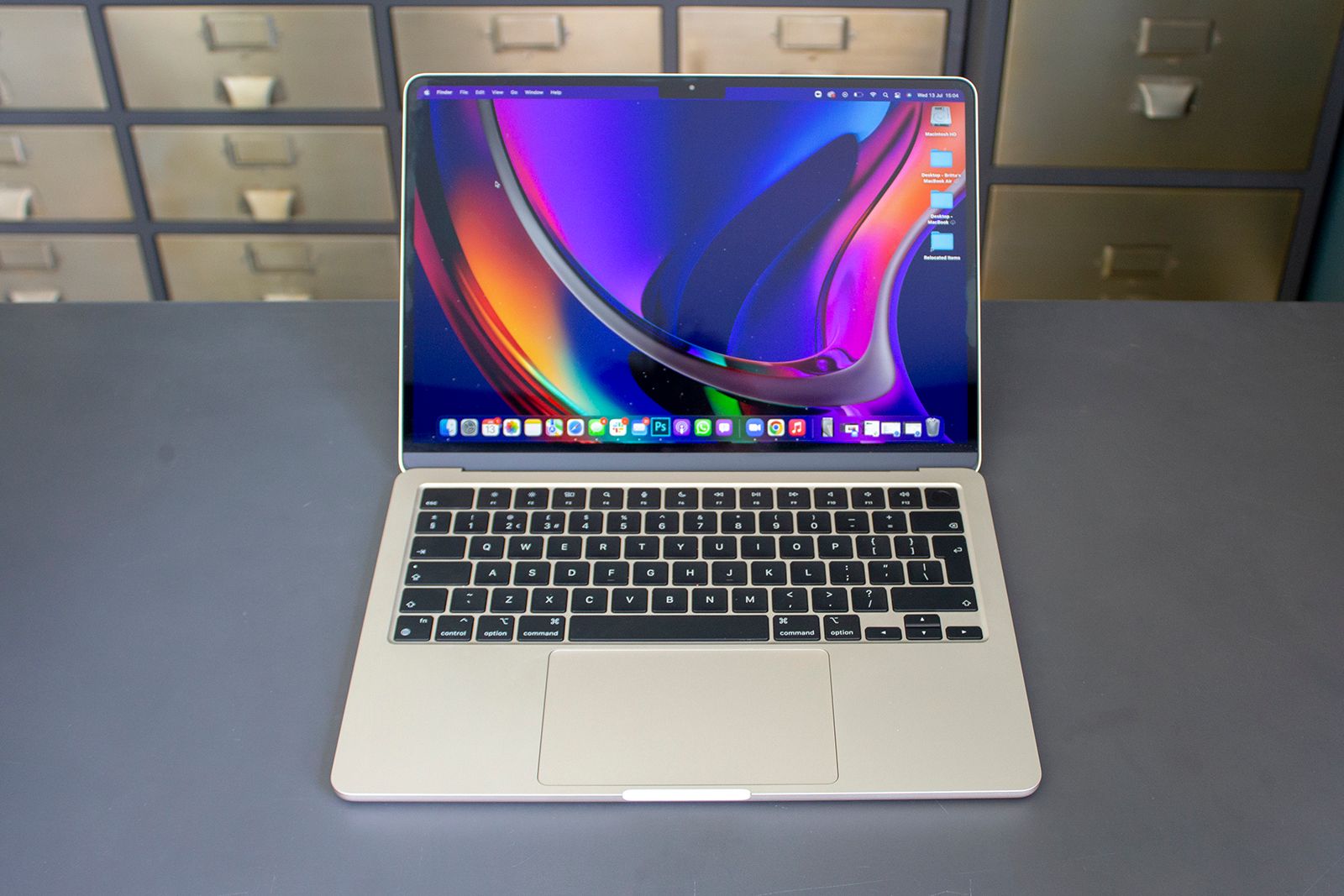 MacBook Air, open, on a desk with filing cabinets in the background