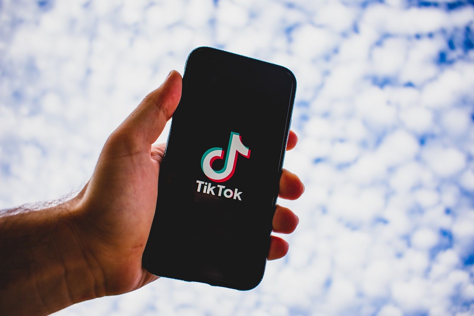 TikTok on a phone with blue sky in the background