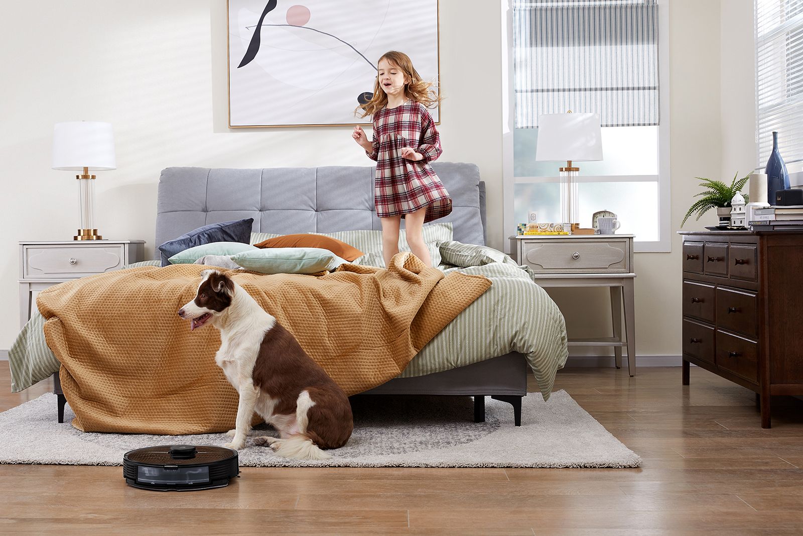 Girl jumps on bed next to dog with Roborock S7 vacuum