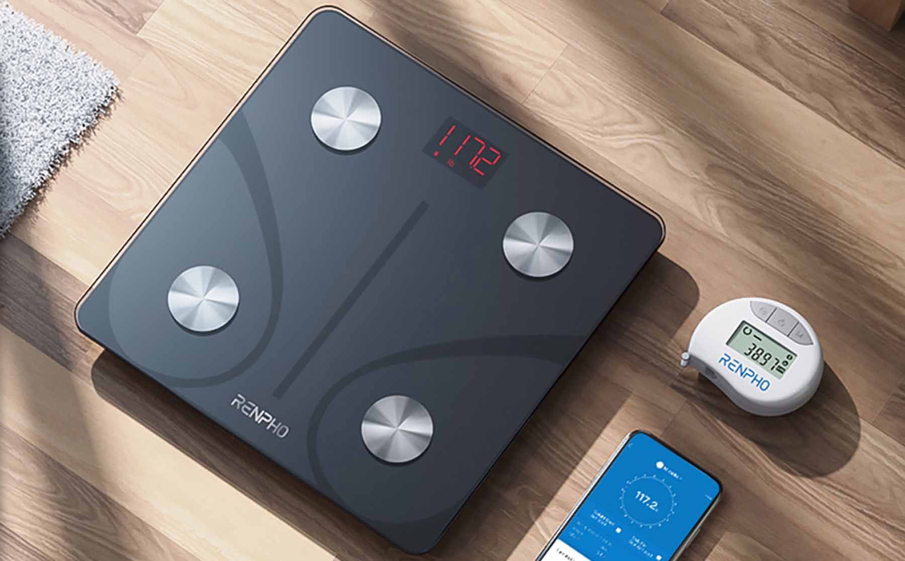 Renpho smart scale on wooden floor with phone and other gadget