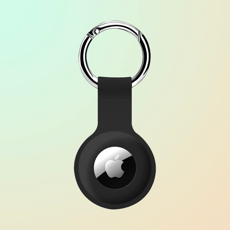 A black silicone case attached to a silver circular clip with an AirTag in the center.