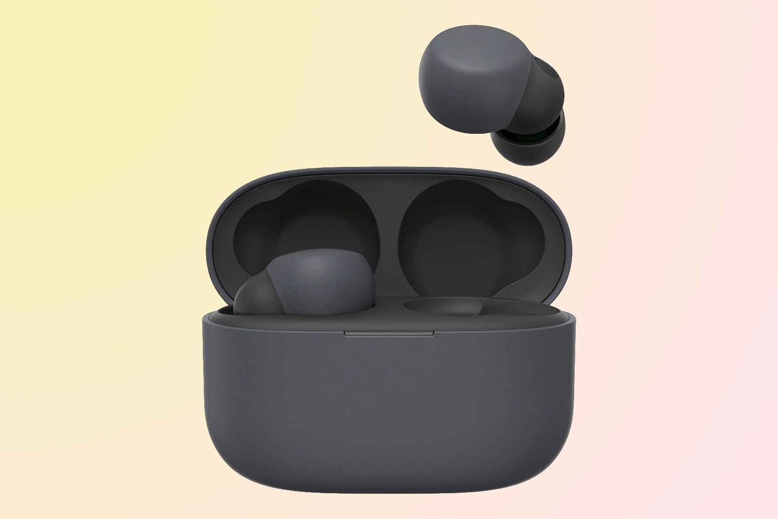A dark grey charging case with two earbuds sitting on top of it.