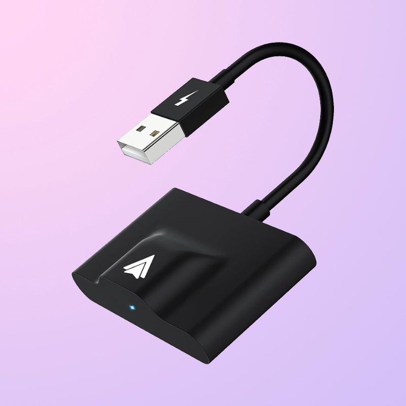 A black rectangle with a bump on the top, a USB-A cable coming out of the side, and an Android Auto logo printed on it.