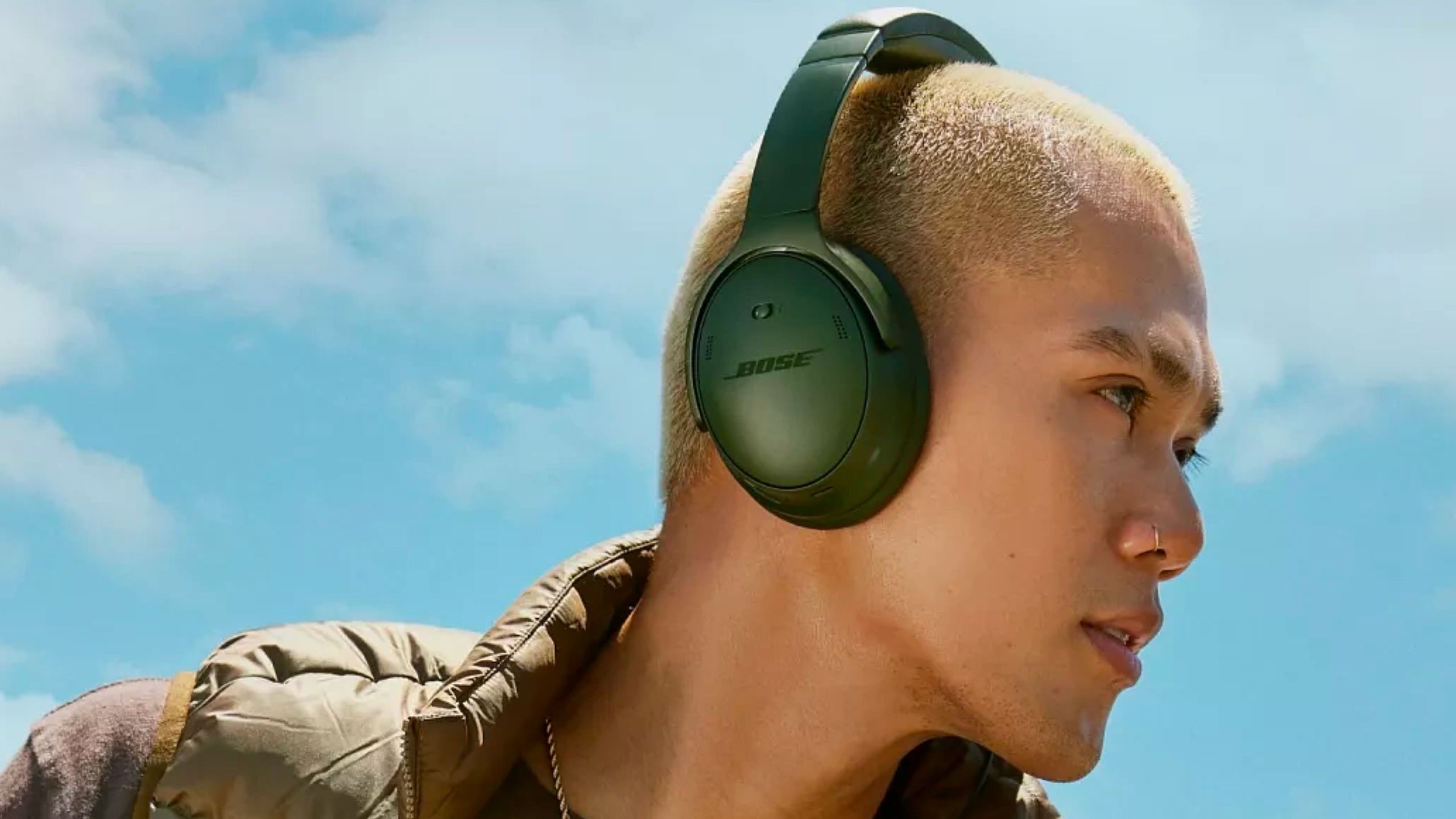 Bose QC over-ear original green headphones on mans head side view