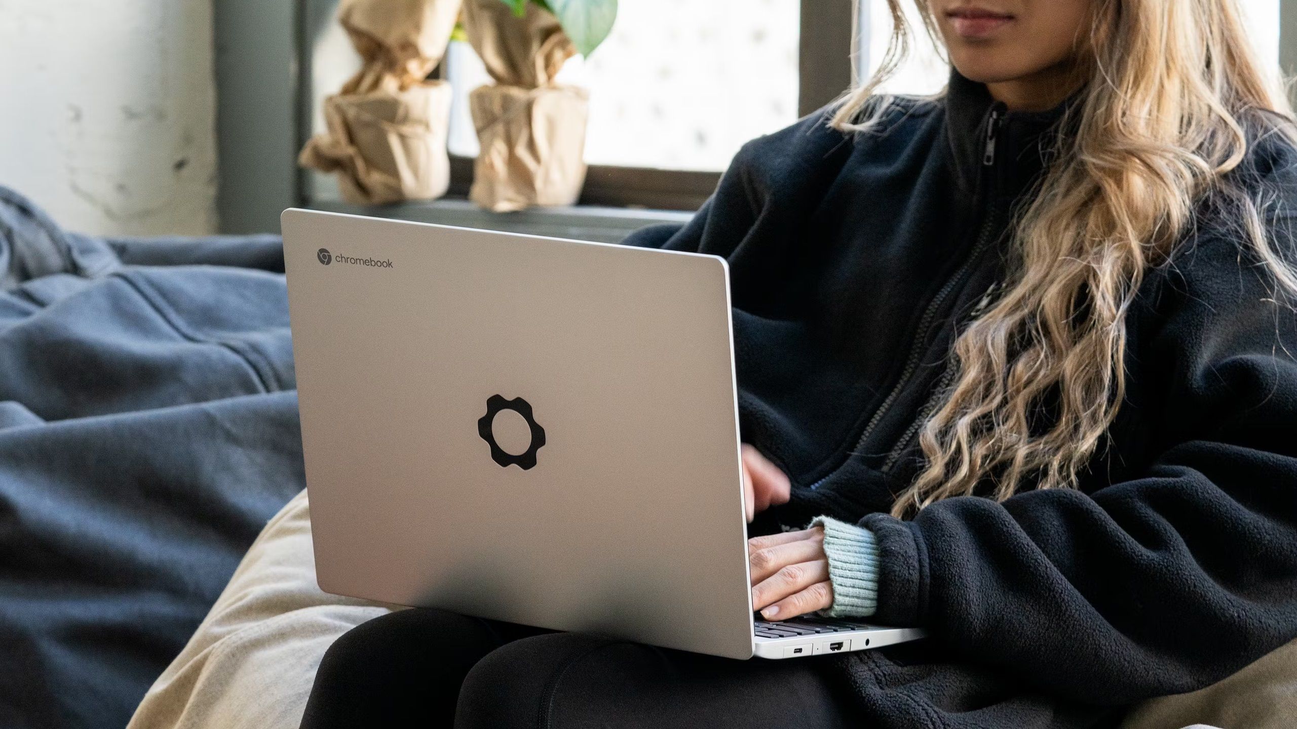 A woman using a Framework Chromebook on her lap.