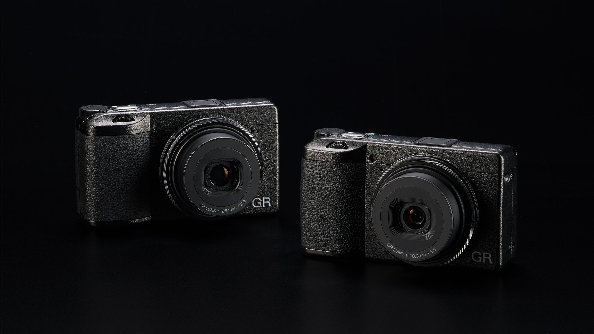 The Rocoh GR II HDF and GR IIIx HDF cameras against a black background