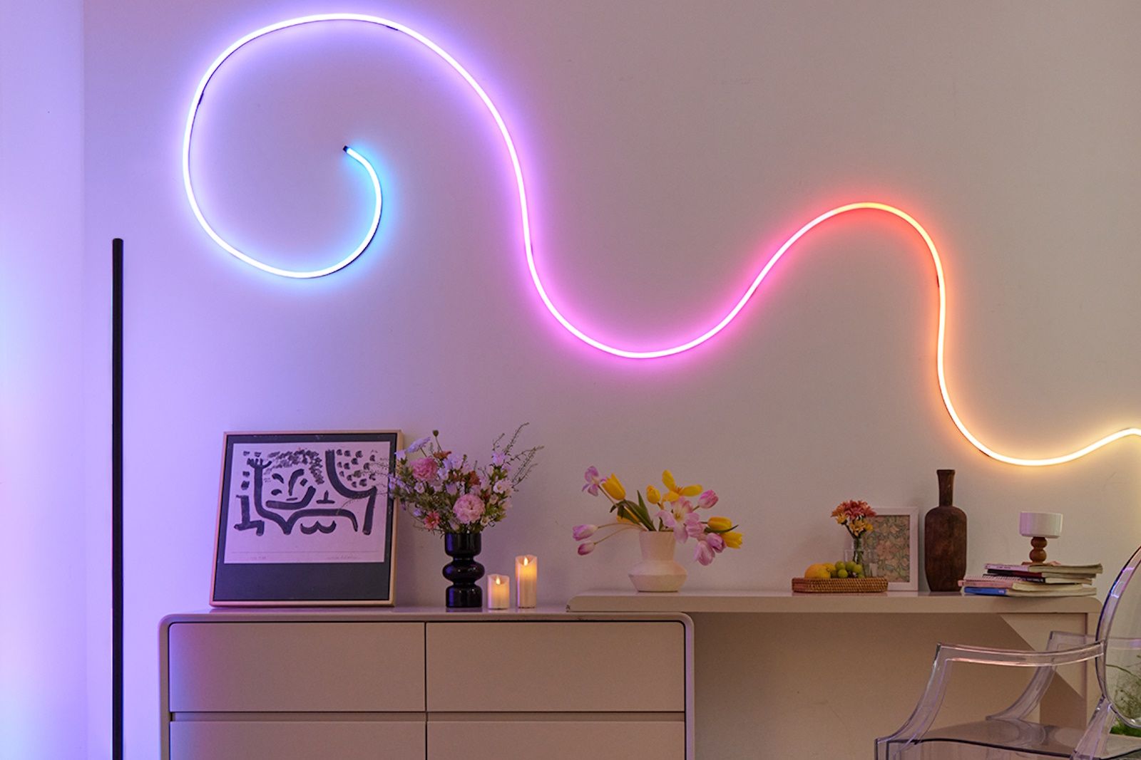 A rainbow-coloured wall-mounted rope light above a desk