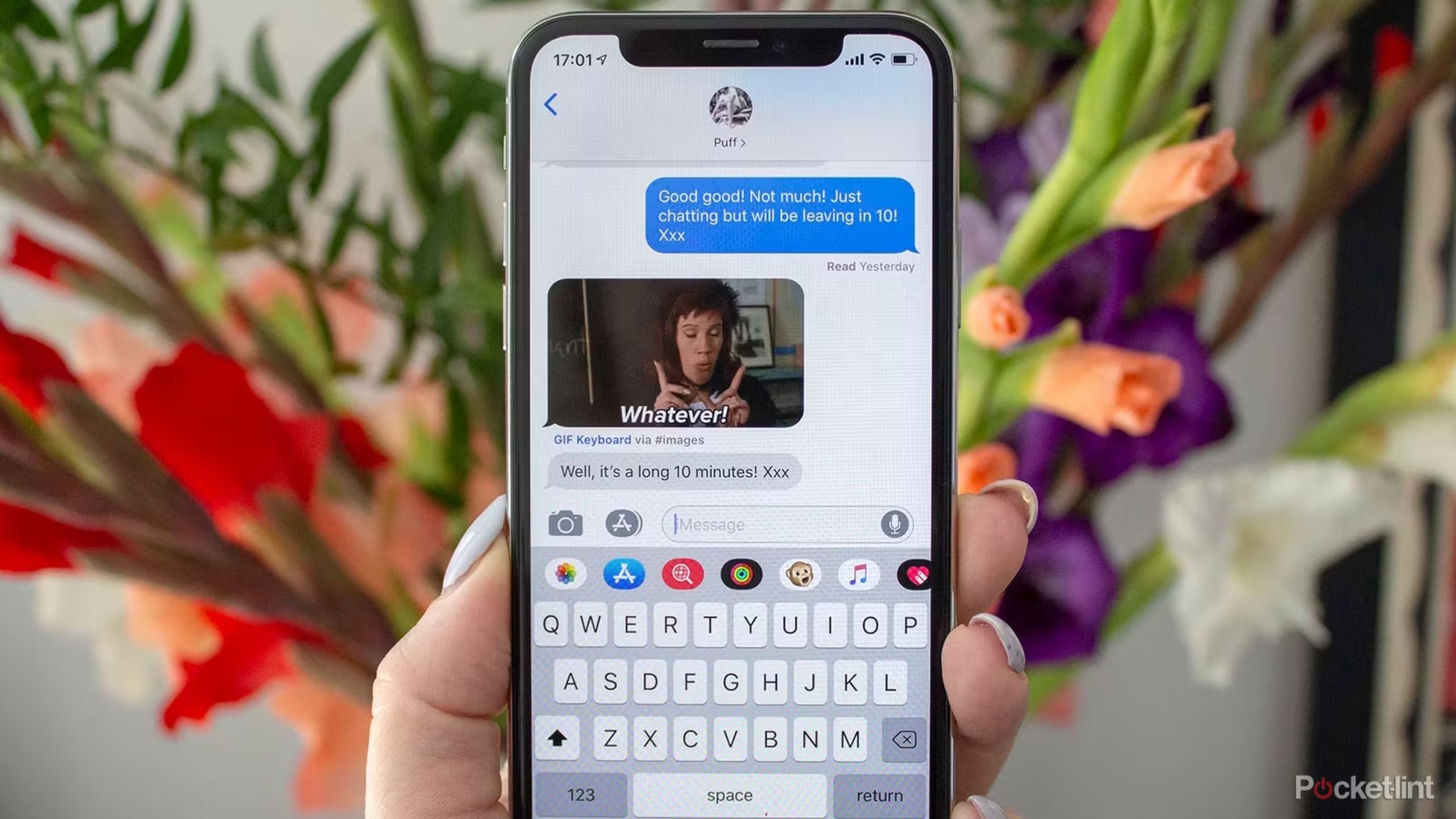 Someone holding an iPhone with iMessage open to a text thread where someone sent a GIF. 