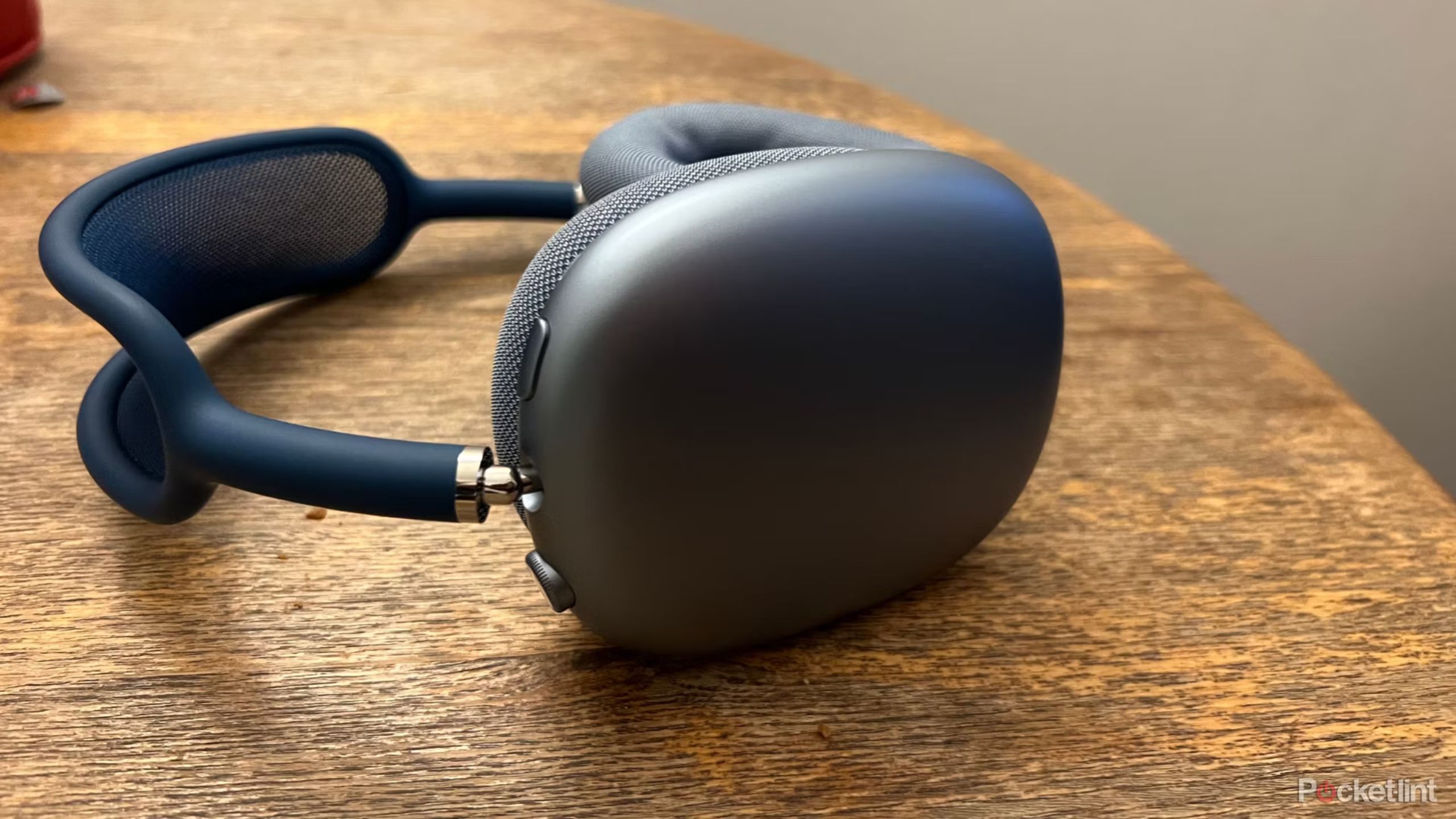 Grey AirPods Max on a wooden surface