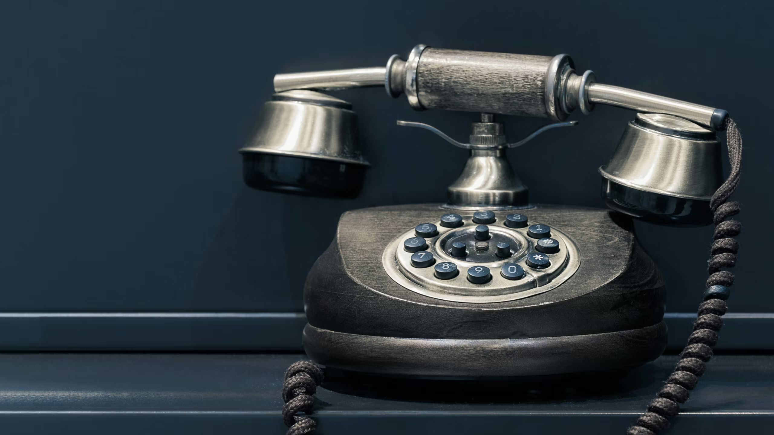 Rotary phone on a desk. 