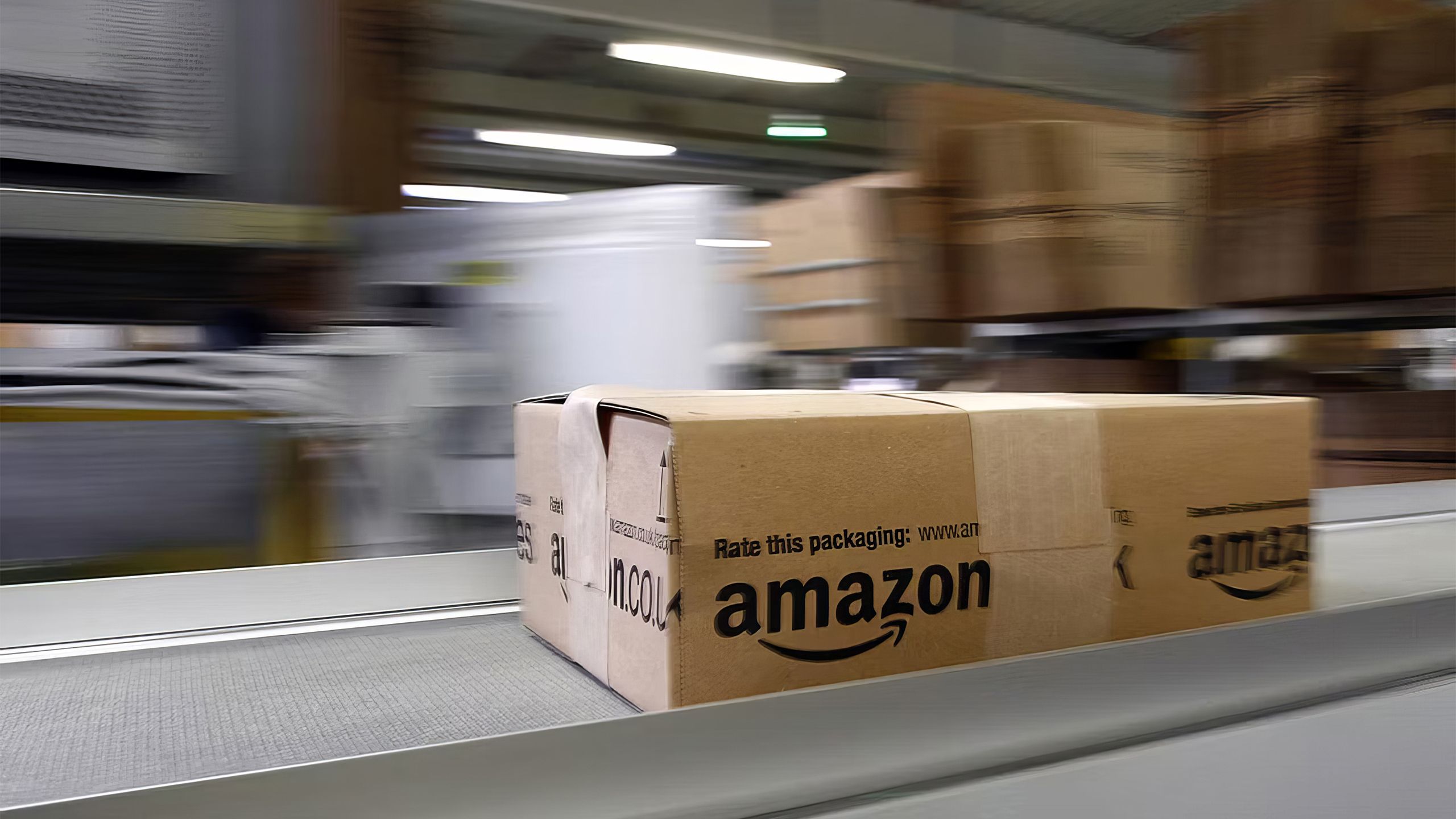 A box slides along a track in a warehouse with a blurred background.