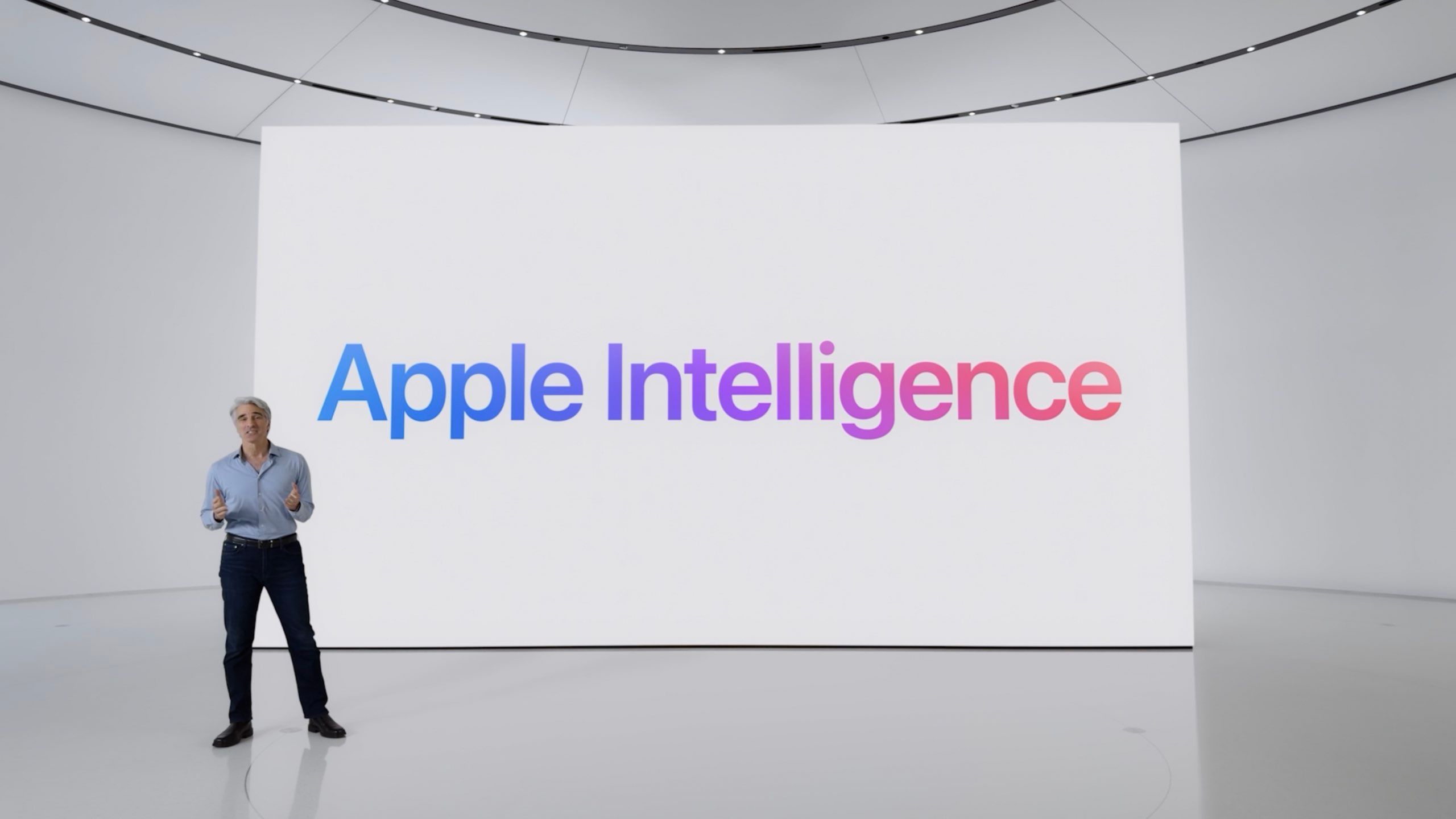 Apple's SVP of Software Engineering stands in front of the Apple Intelligence keynote slides