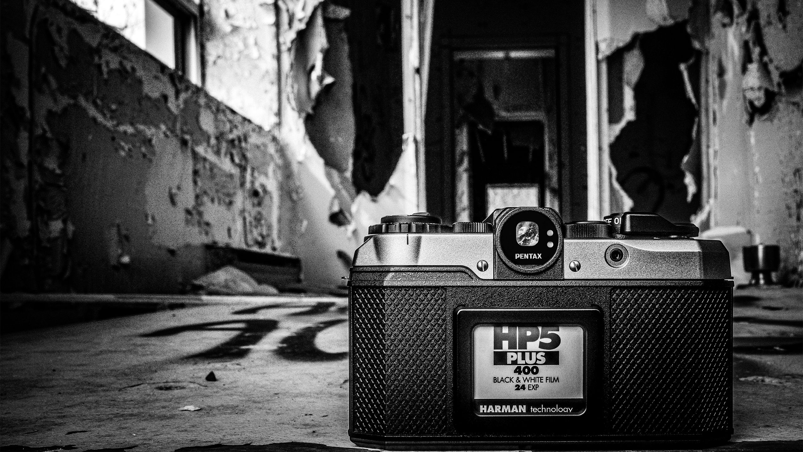 A Pentax 17 in front of an abandoned building in black and white. 
