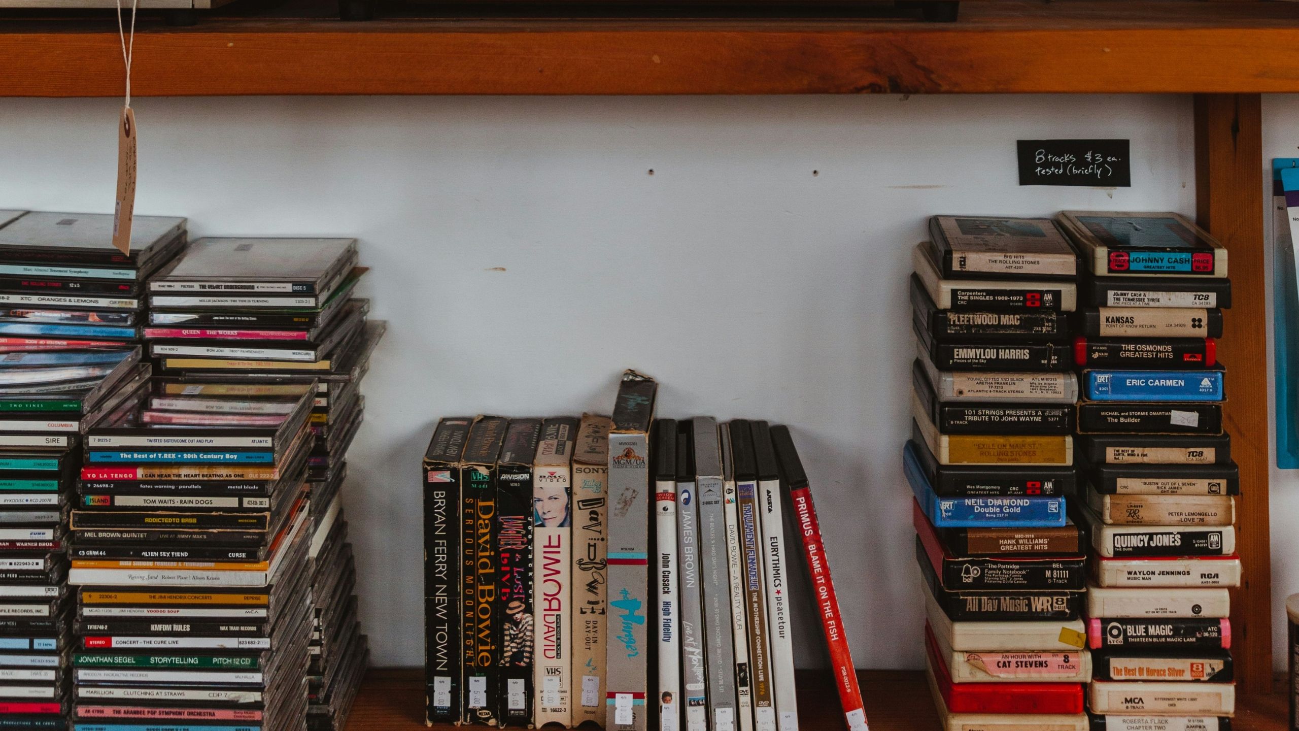 CDs and cassette taps on a shelf. 