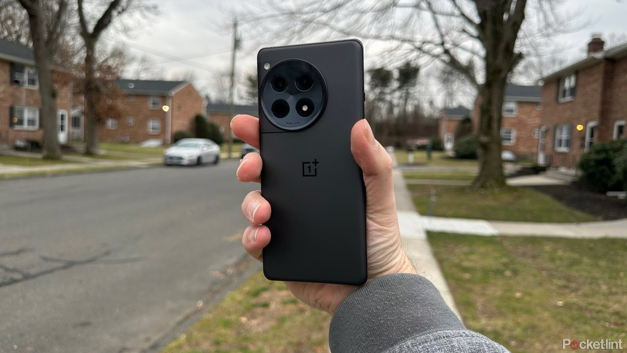 Holding the back of the OnePlus 12R outside.