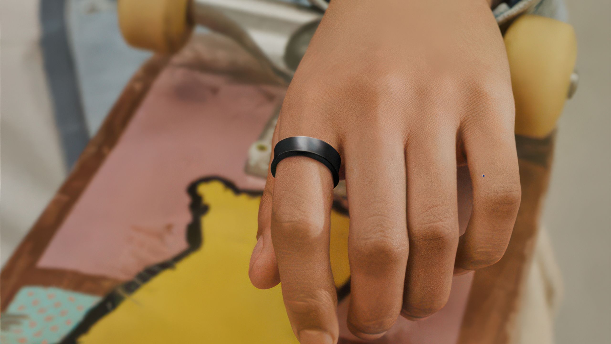 A hand with the black Samsung Galaxy Ring.