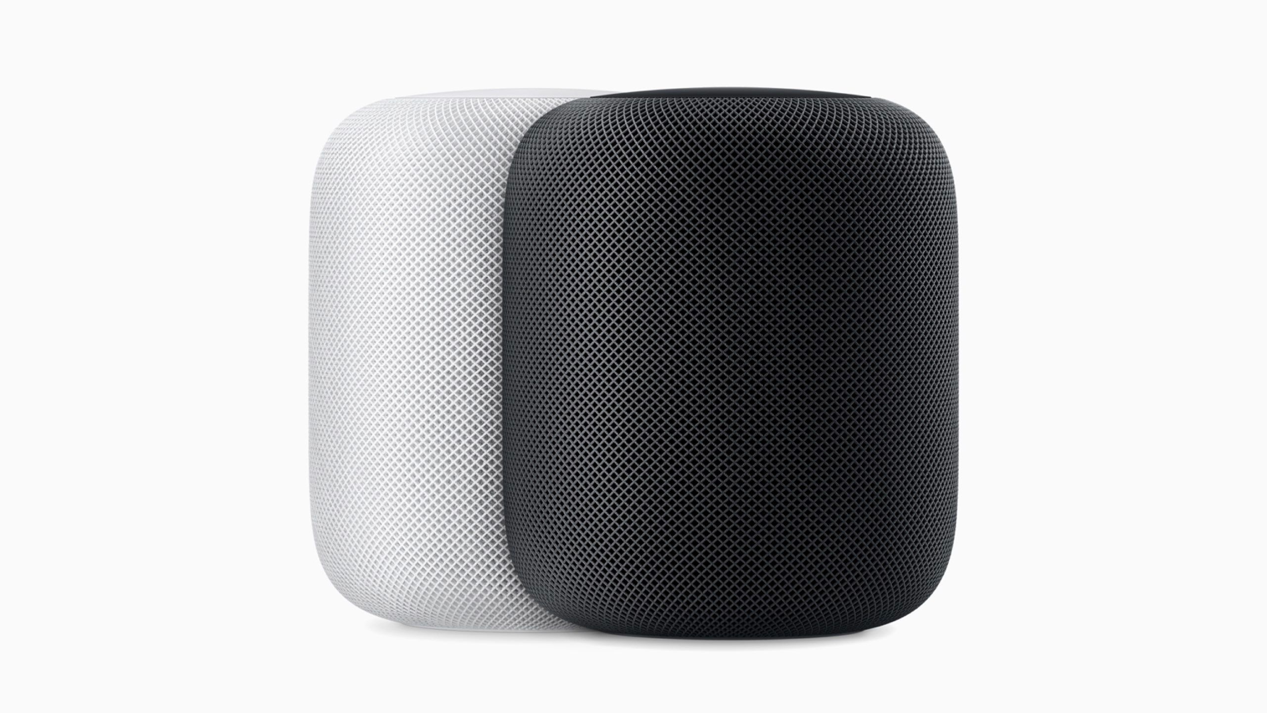 An Apple marketing image of a white and space grey 1st generation HomePod. 