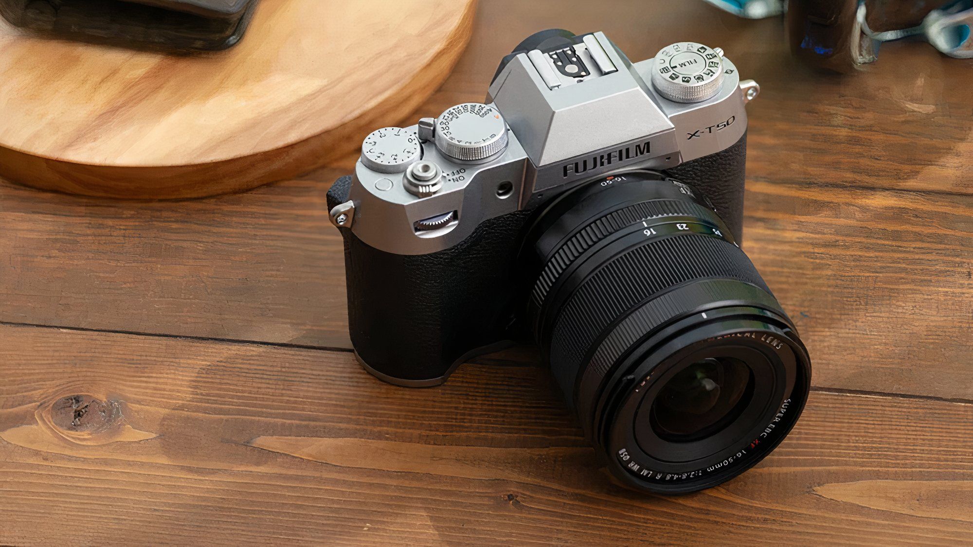 The Fujifilm X-T50 is shown sitting on a wooden table