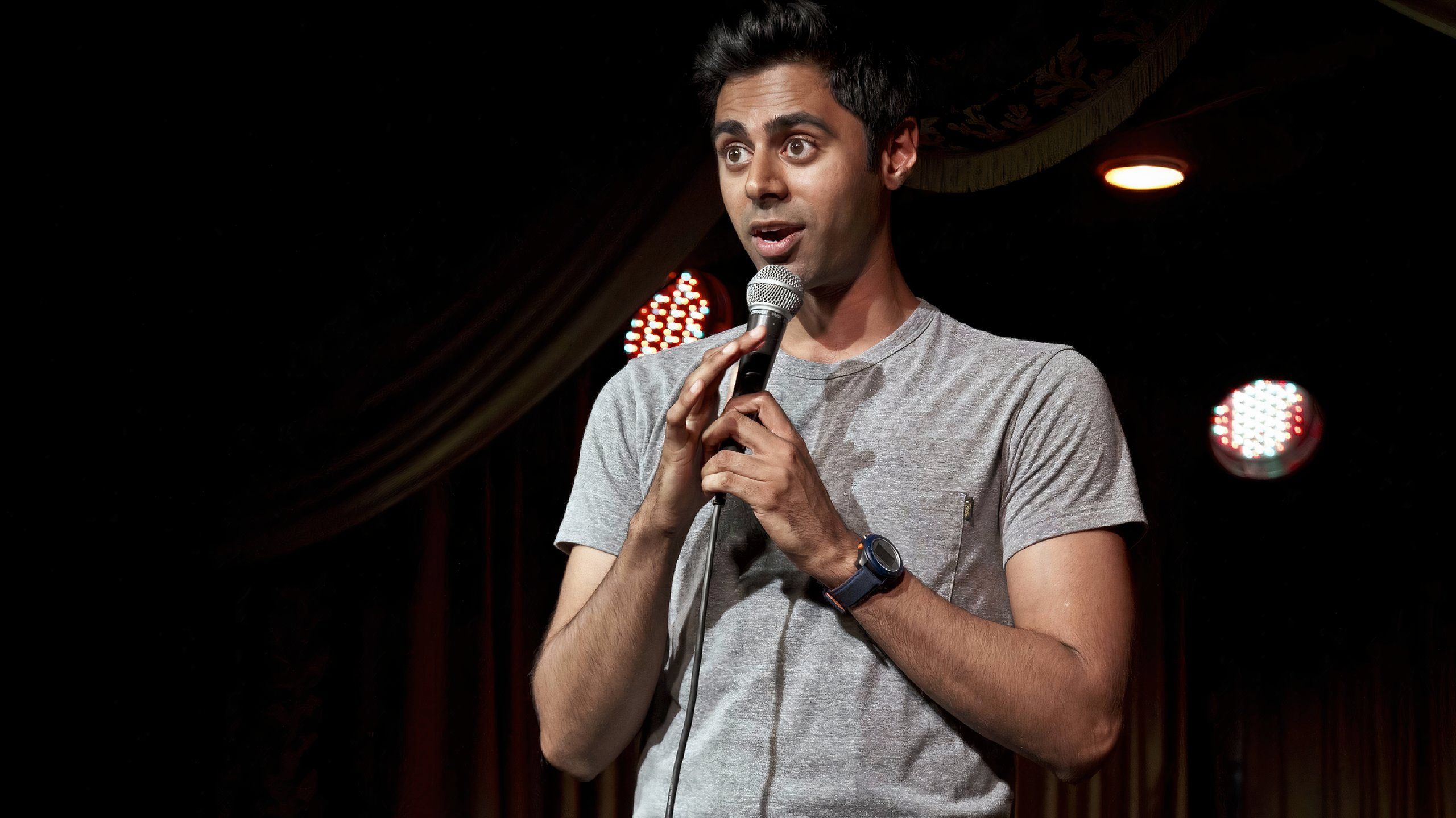 hasan minhaj speaking into a mic