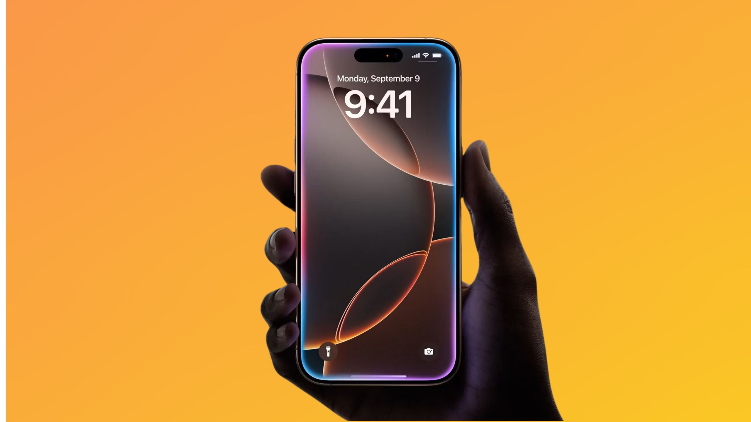 iPhone 16 Pro held in hand on colored background