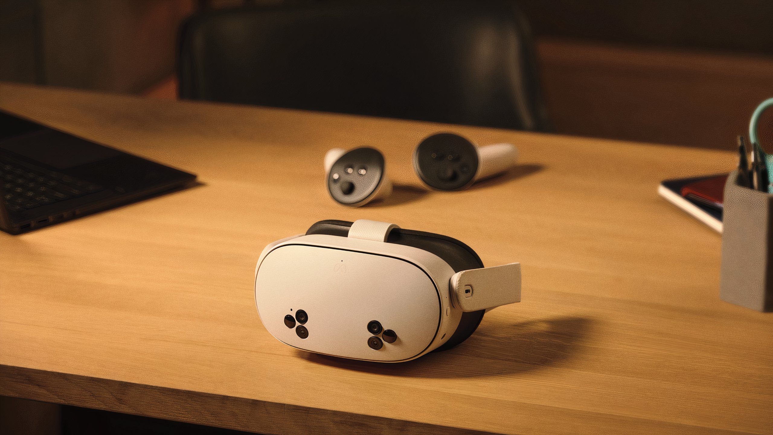 The white VR headset has six black cutouts on the front, placed in front of some round VR controllers.