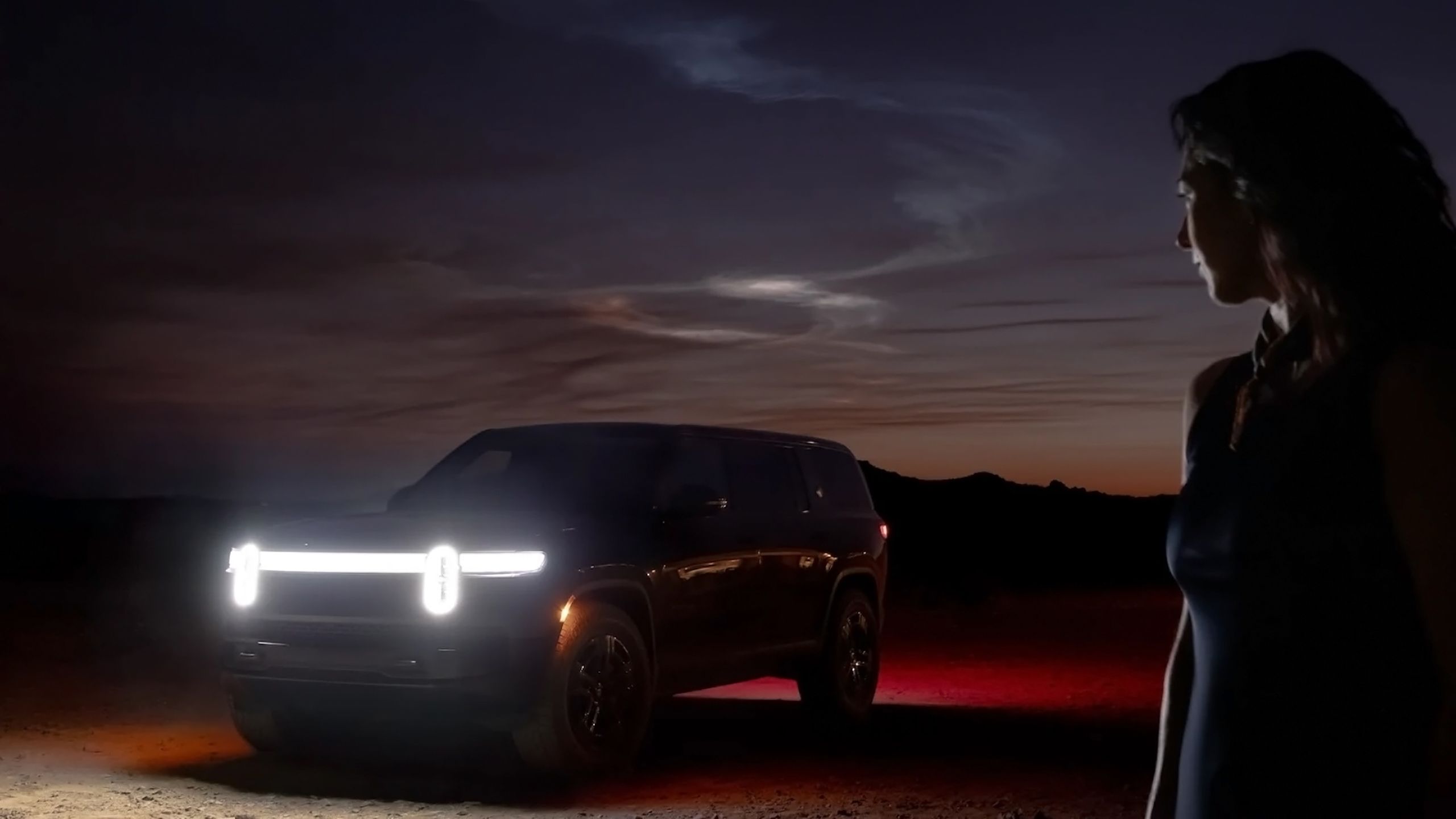 A Rivian SUV at night.