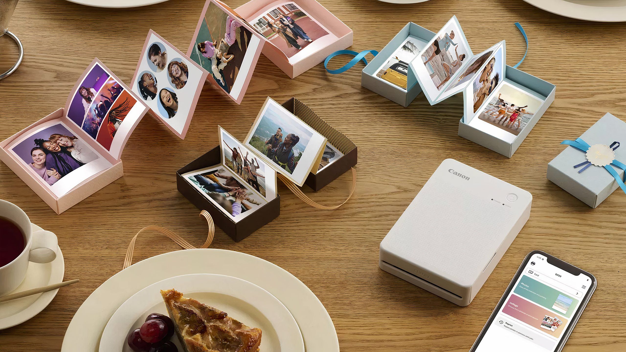 The Canon Selphy QX20 sitting on a table with food and prints