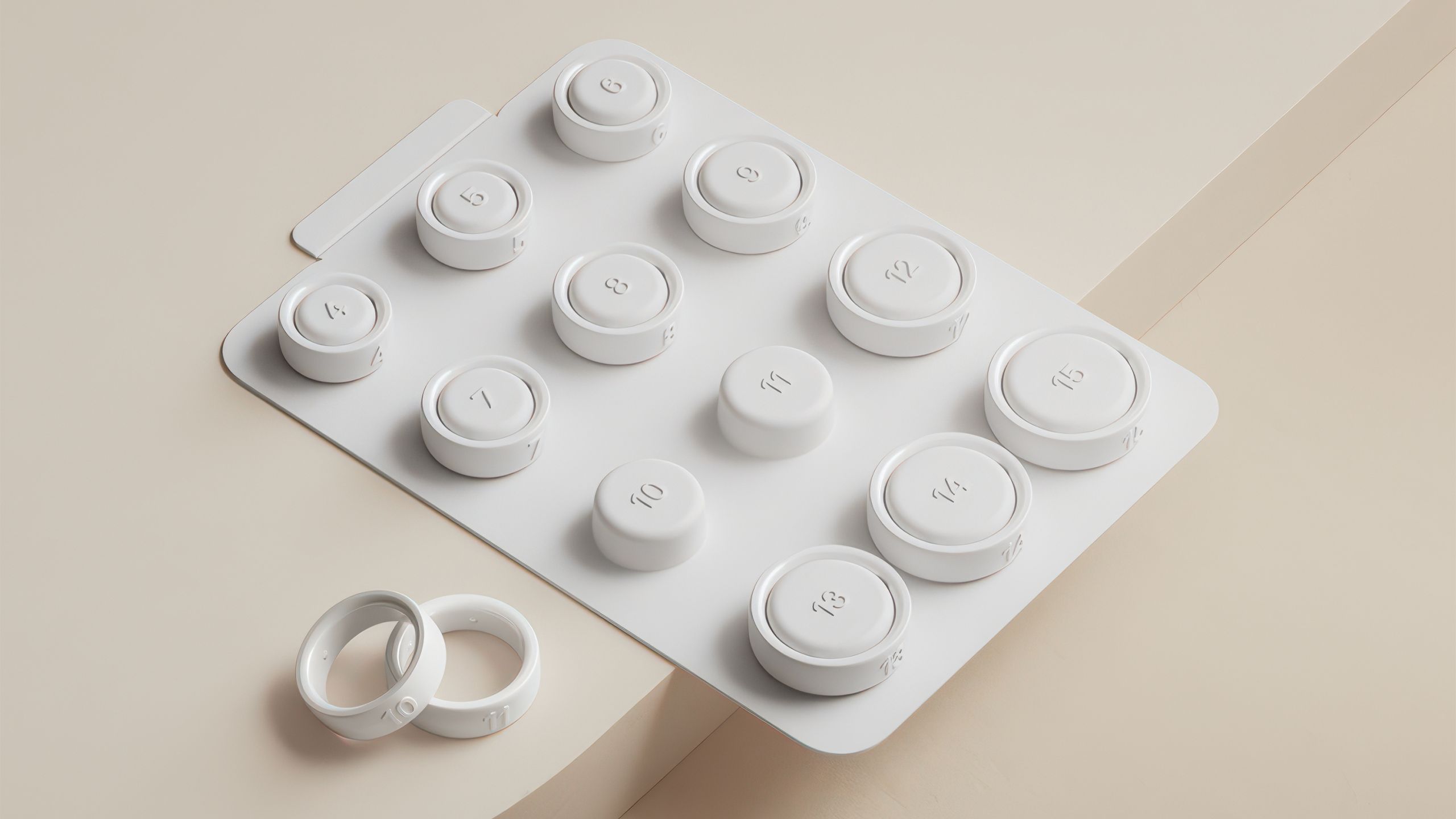 The white Oura Ring 4 sizing kit rests o a cream colored surface. 