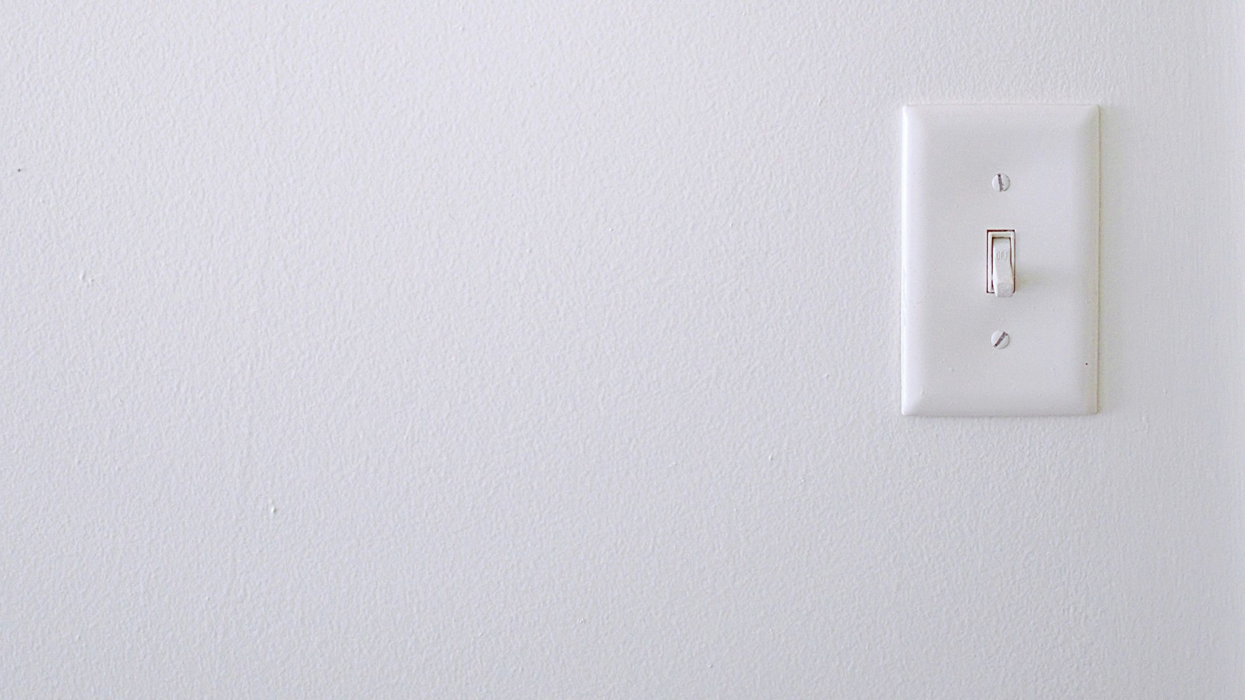 A light switch on a white wall