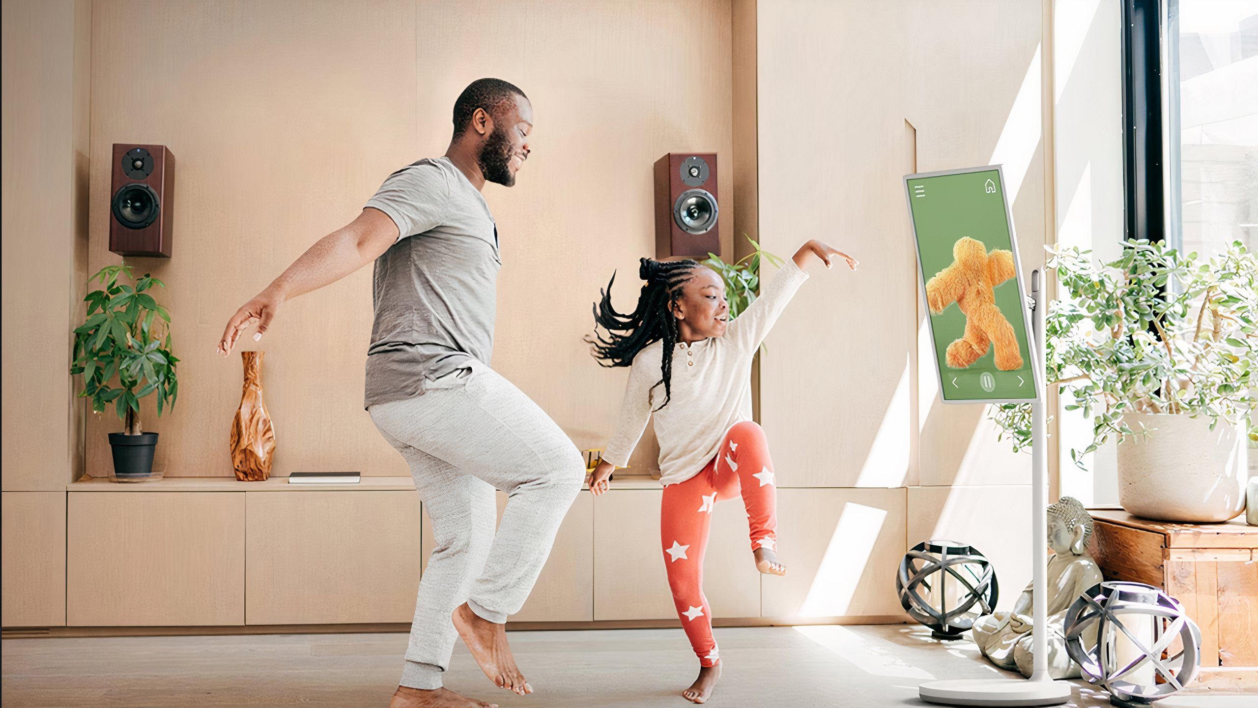 Adult and child dancing in front of a TV