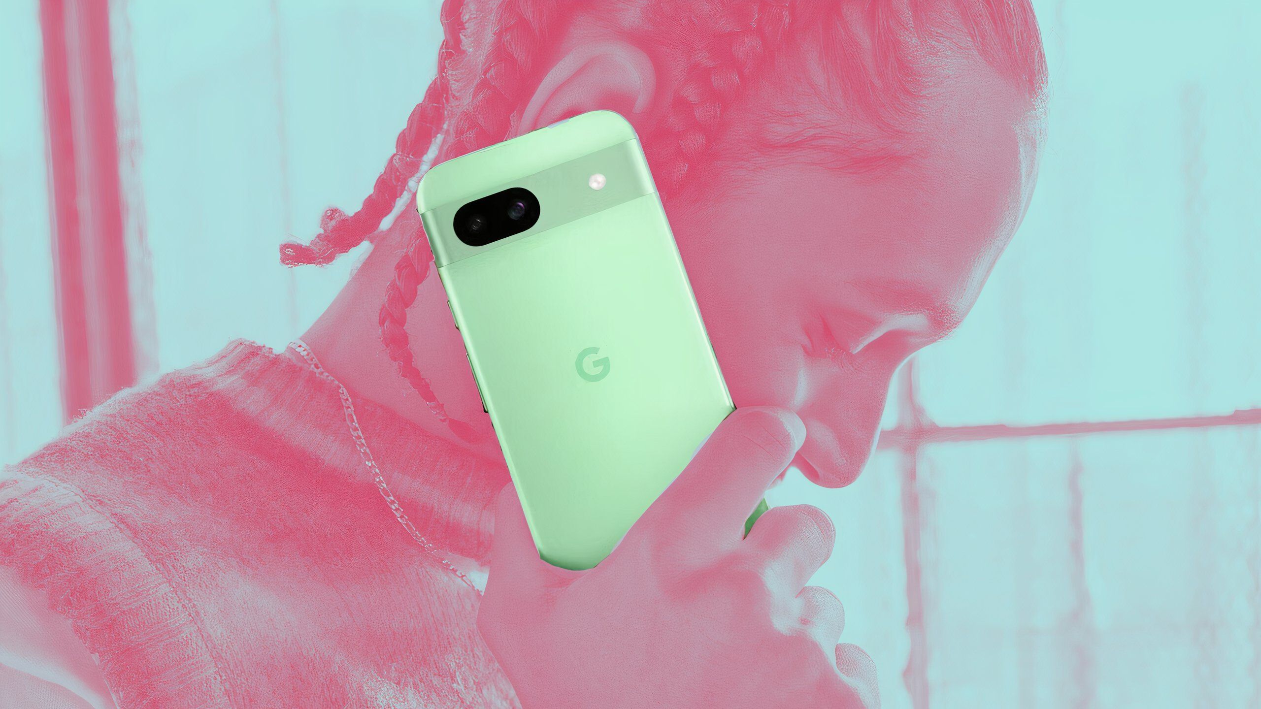 A picture of someone holding an Aloe green Pixel 8a where only the Pixel 8a isn't a pastel red.