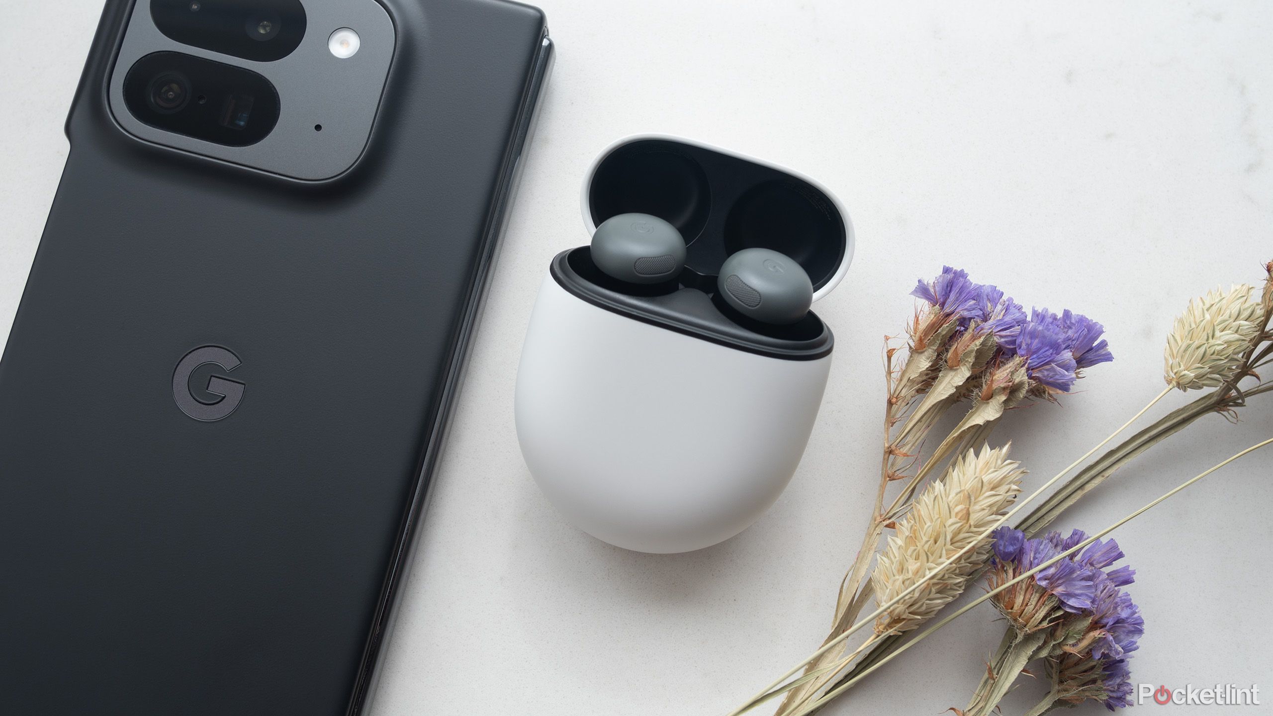 Google's Pixel Buds Pro 2 next to a Pixel 9 Pro Fold.