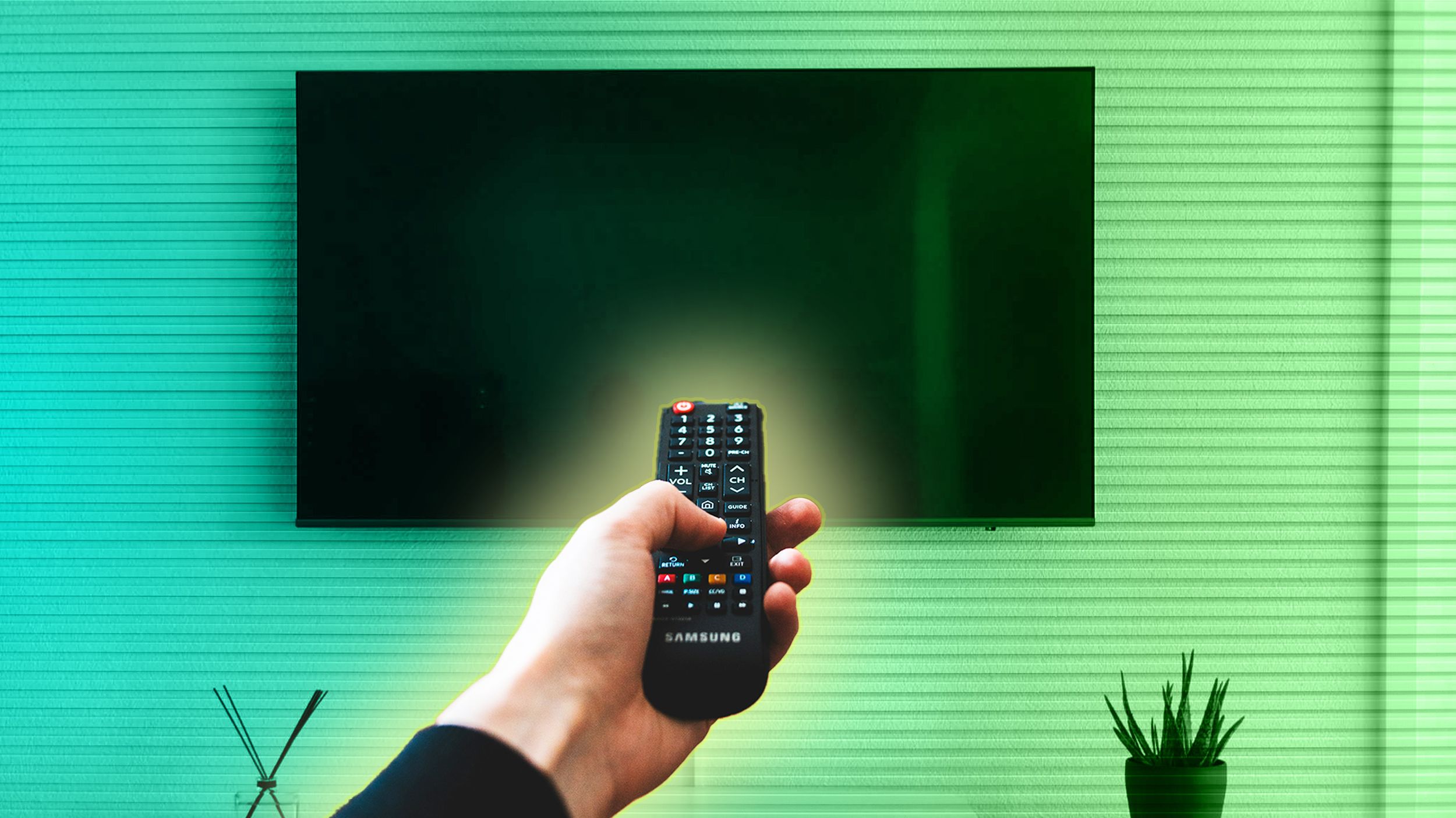 A person pointing a remote at a blank TV.