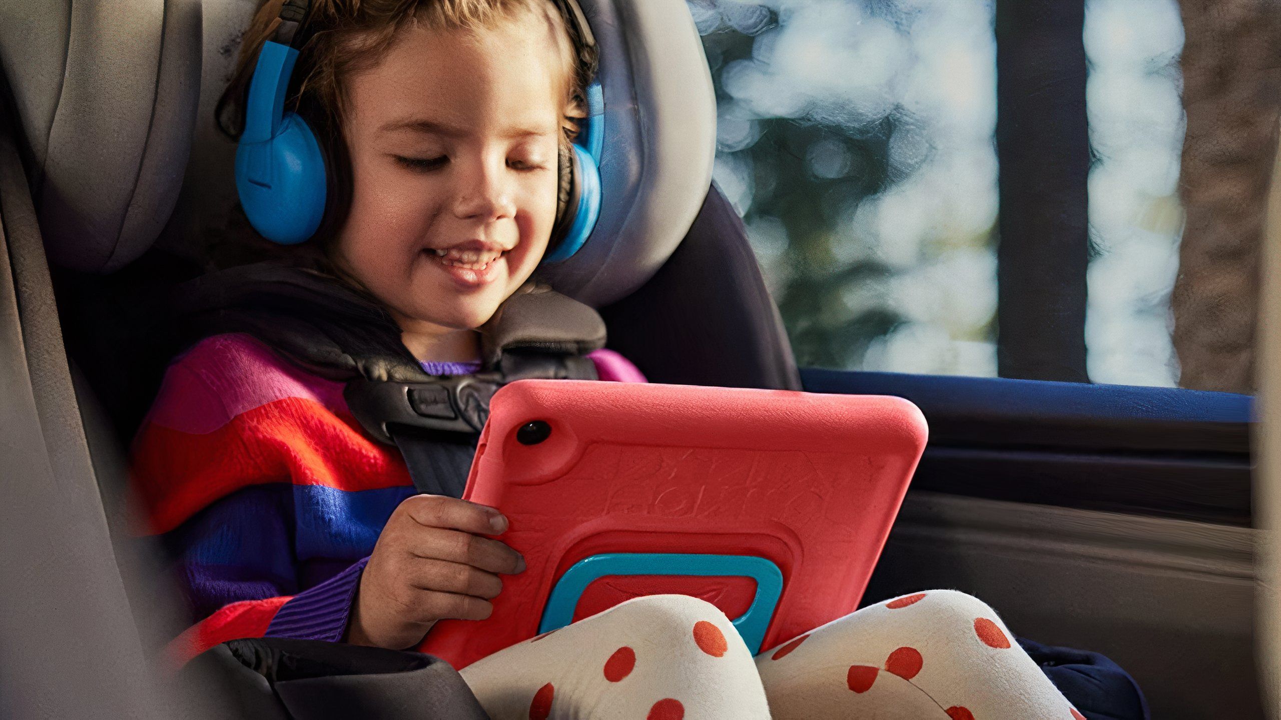 A girl watching an Amazon Fire 7 kids tablet in a car