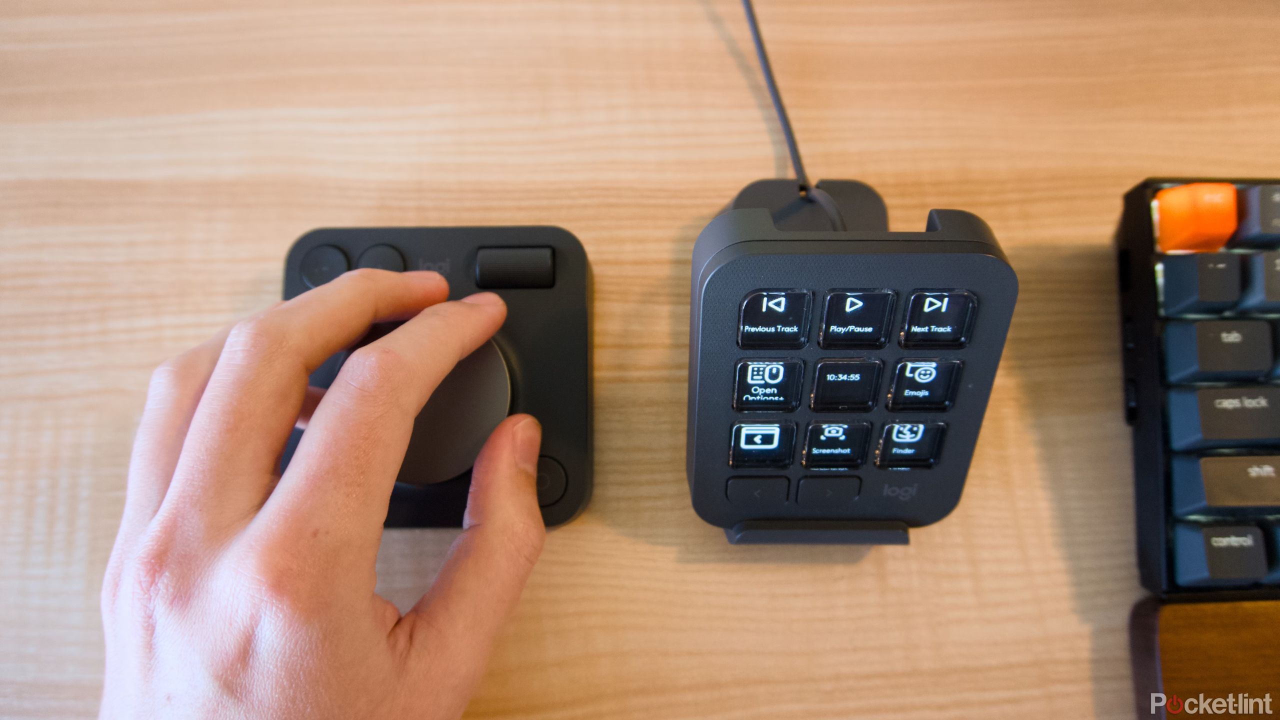 A hand adjusting a dial next to a keypad.