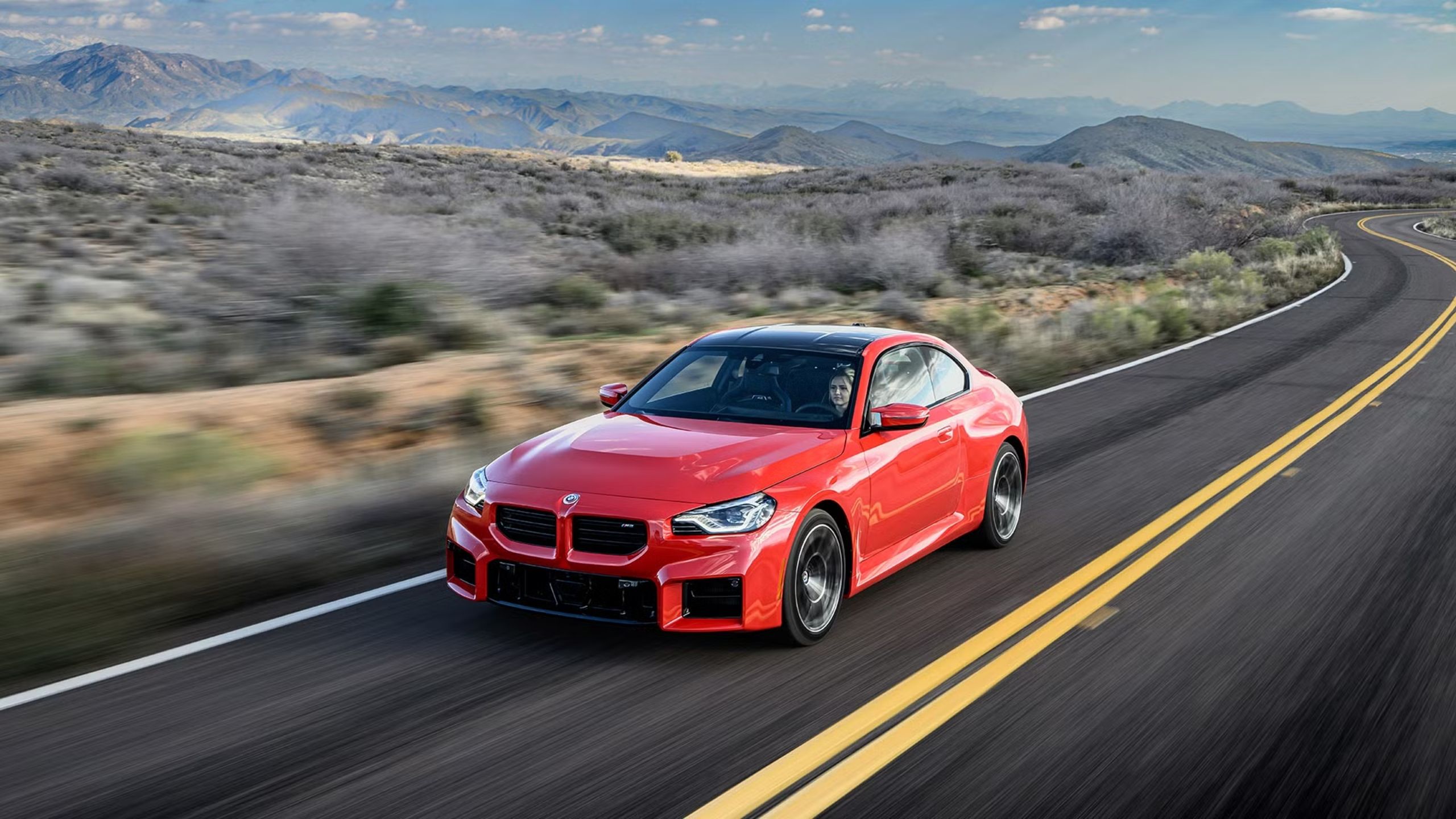 front quarter view of the 2025 BMW M2 driving on road