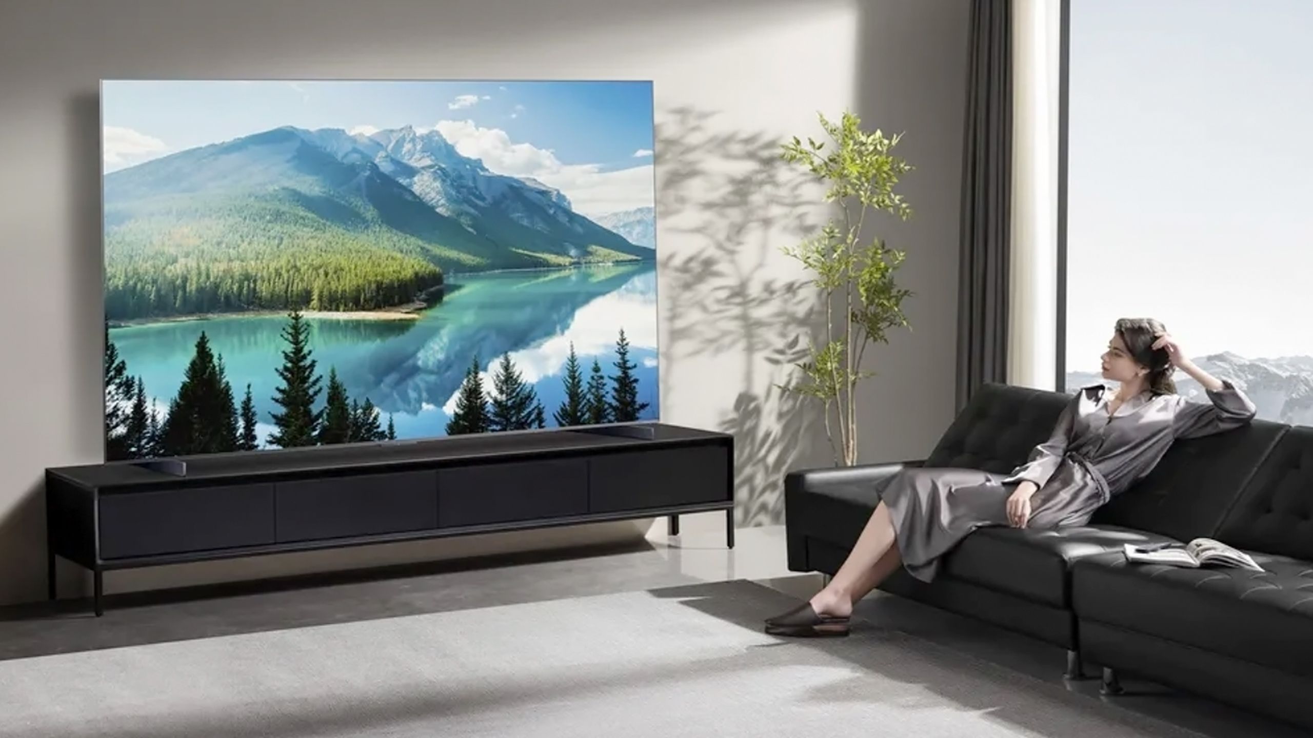 A model watches TCL's QM8K mini-LED TV.