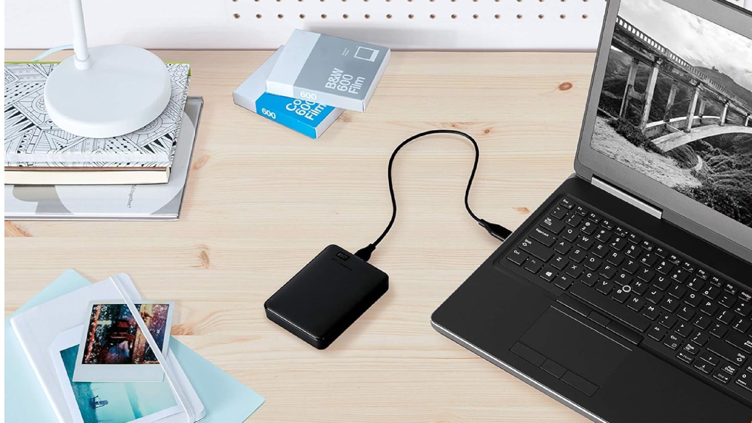 An external hard drive going into a laptop. 