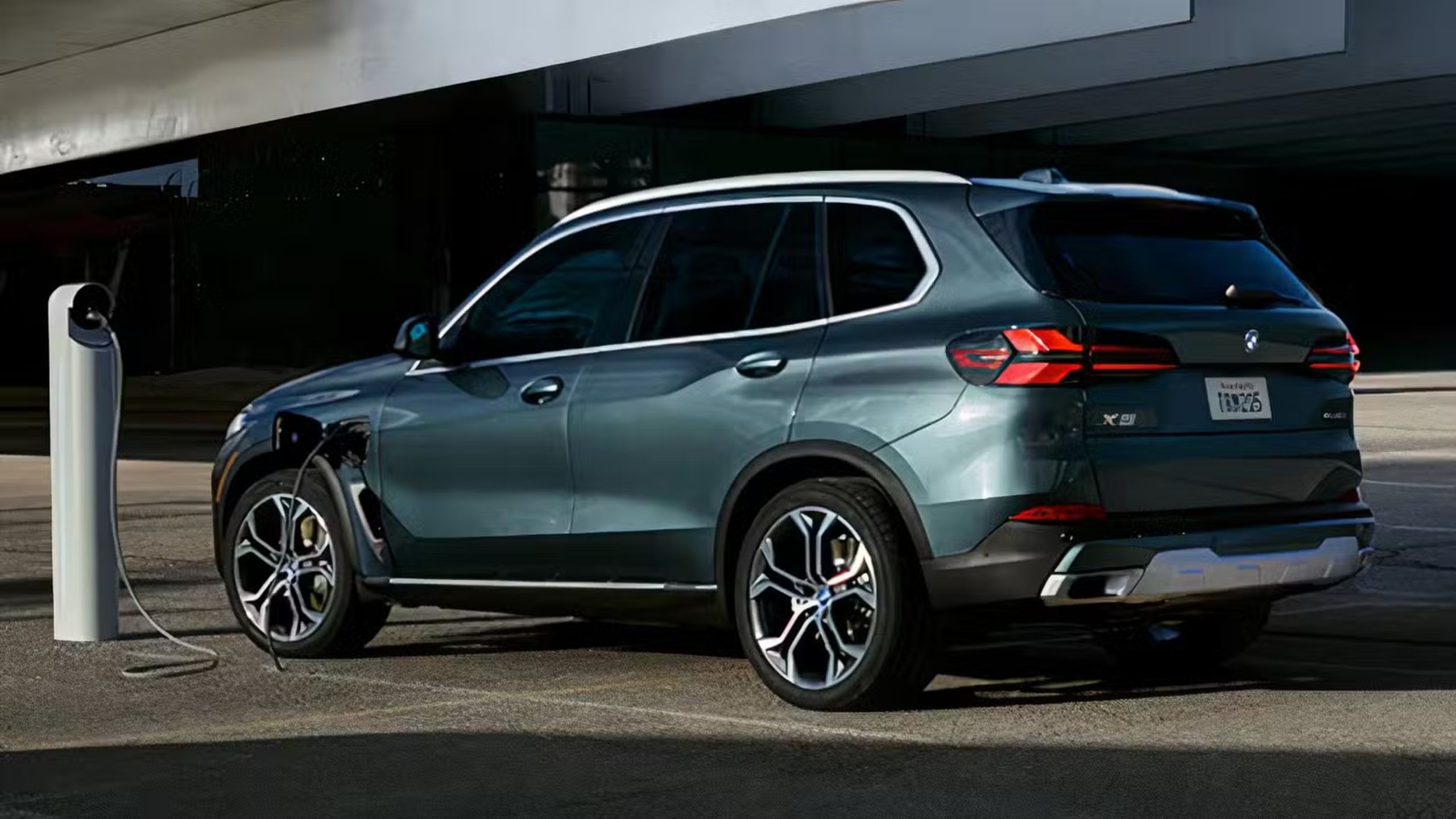 Rear quarter view of the BMW X5 PHEV charging.