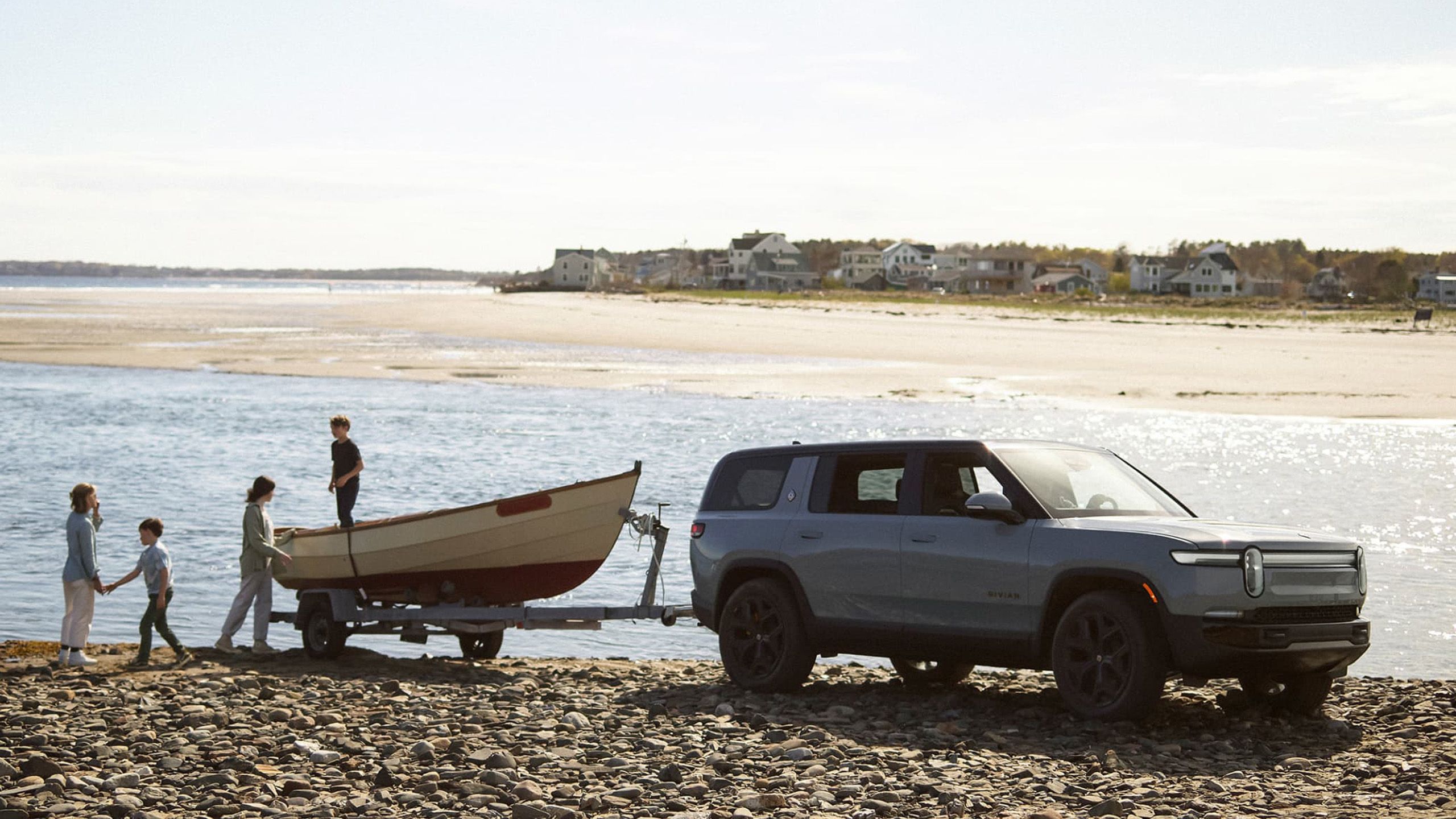 A Rivian R1S towing a fishing boat.