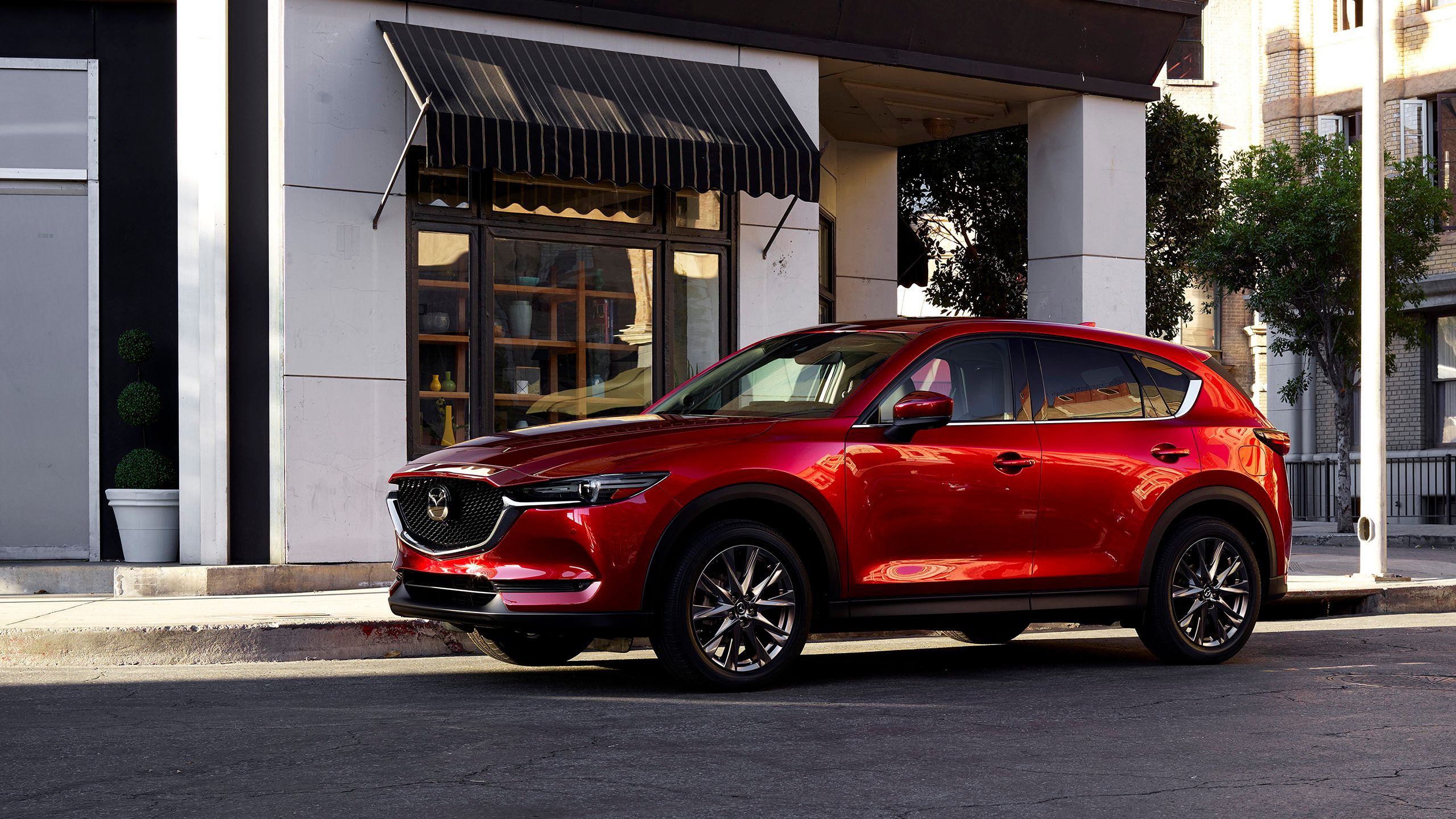 A red 2021 Mazda CX-5 parked on a curb. 