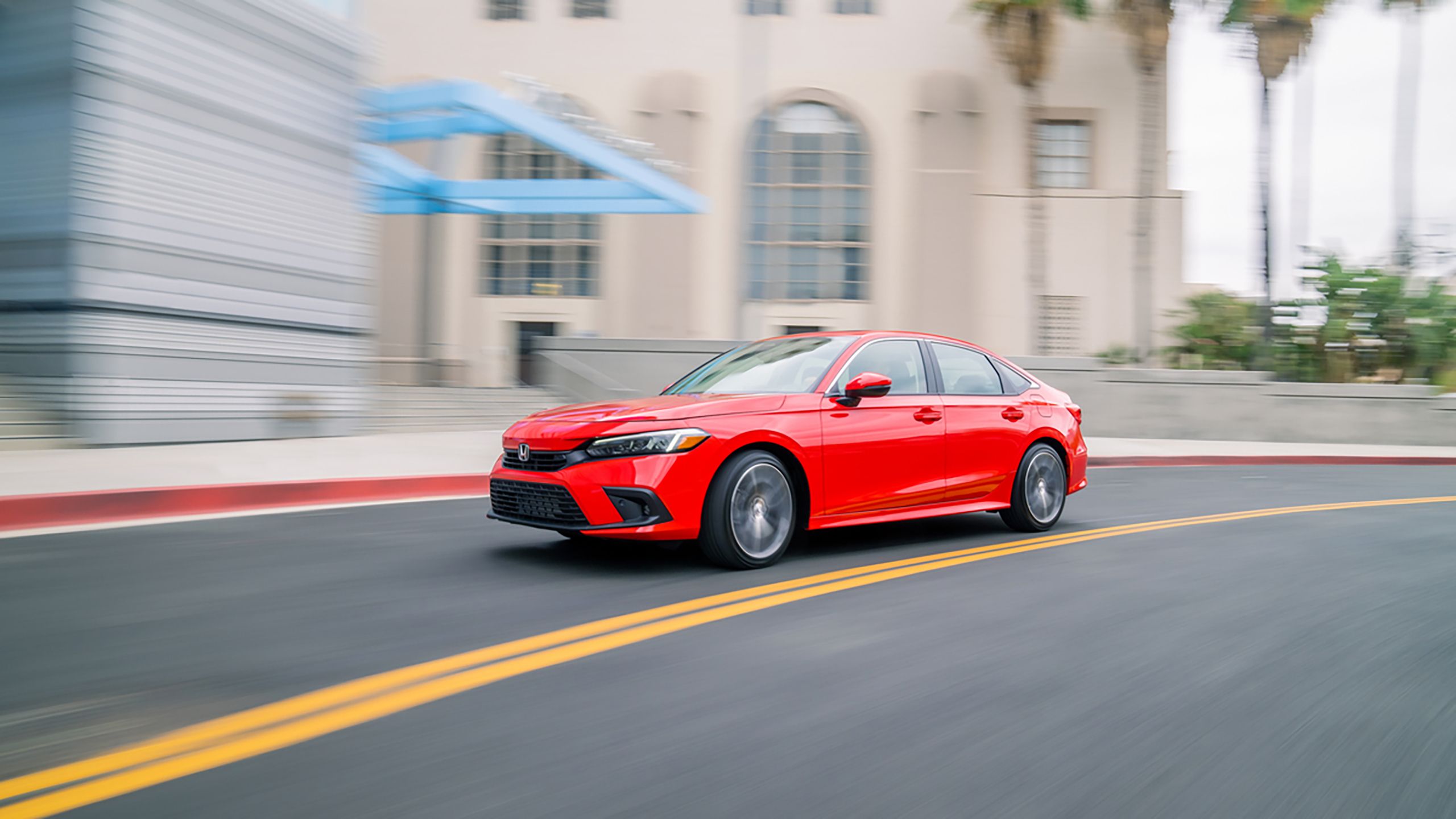 A red 2022 Honda Civic rounding a corner. 