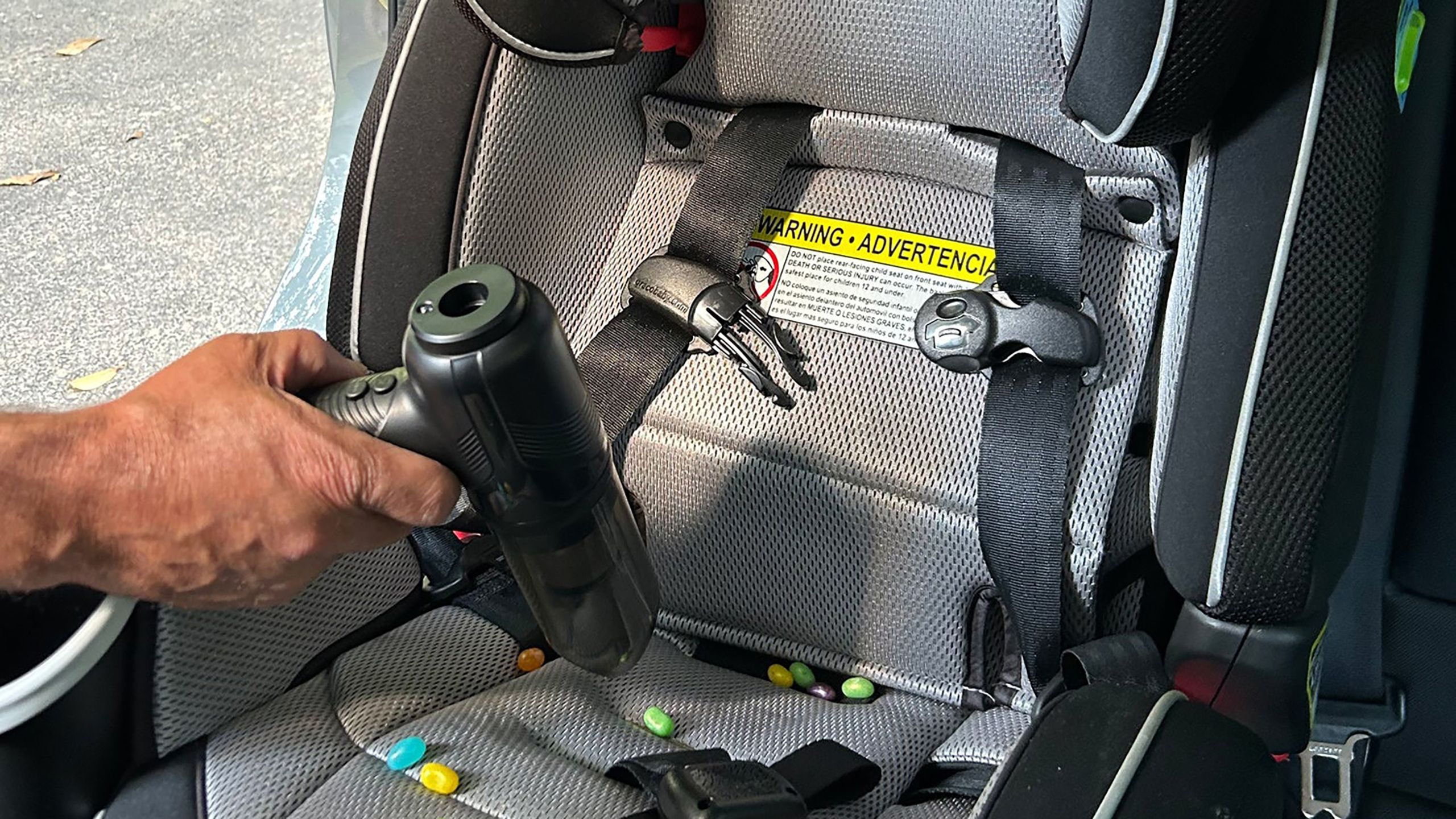 A hedgehog turbovac is being used to clean the car seat. 