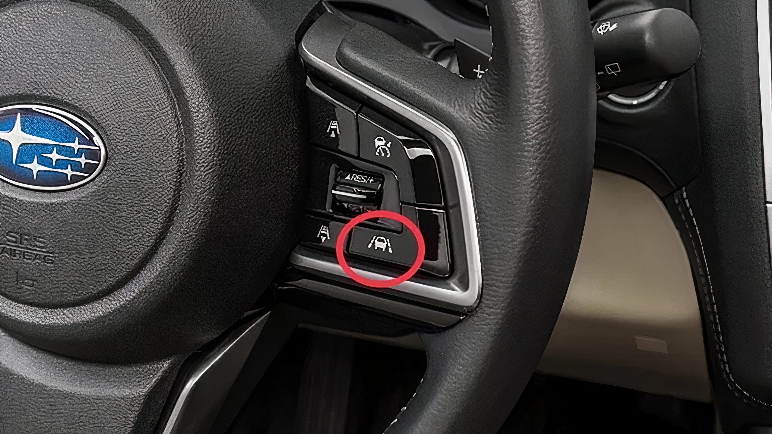 A still photo of a Subaru steering wheel with the lane-keep assist on/off button circled in red. 