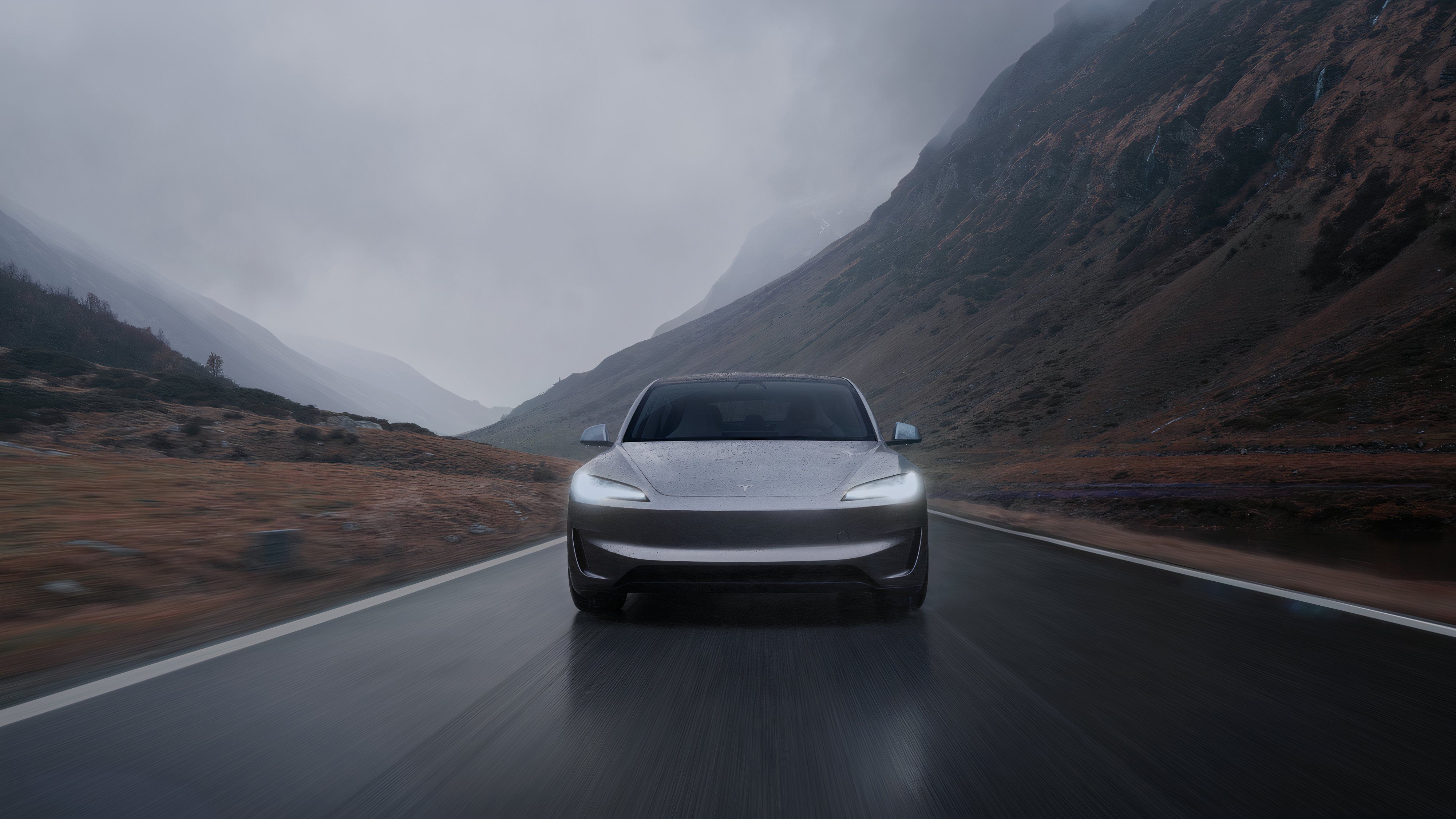A 2024 Tesla Model 3 driving on a wet road. 
