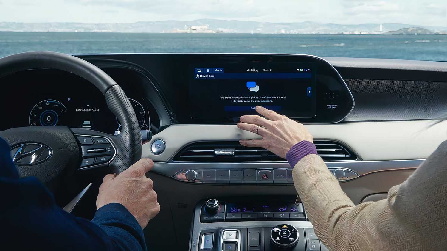 A still photo of a passenger using the Hyundai Blue Link infotainment system. 