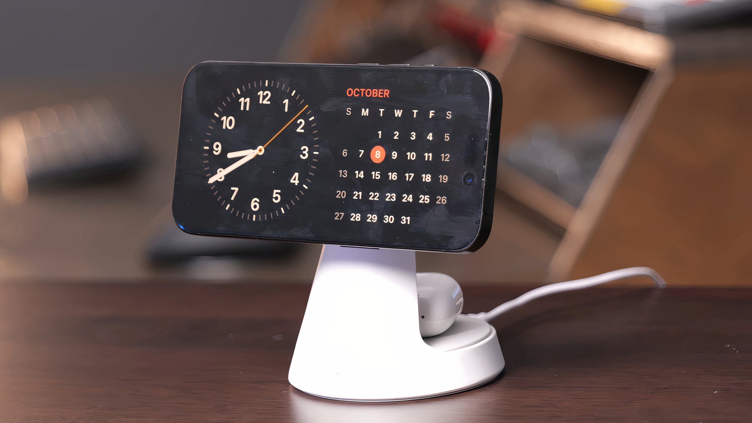 An iPhone charging on a white wireless charging stand displaying Standby Mode.