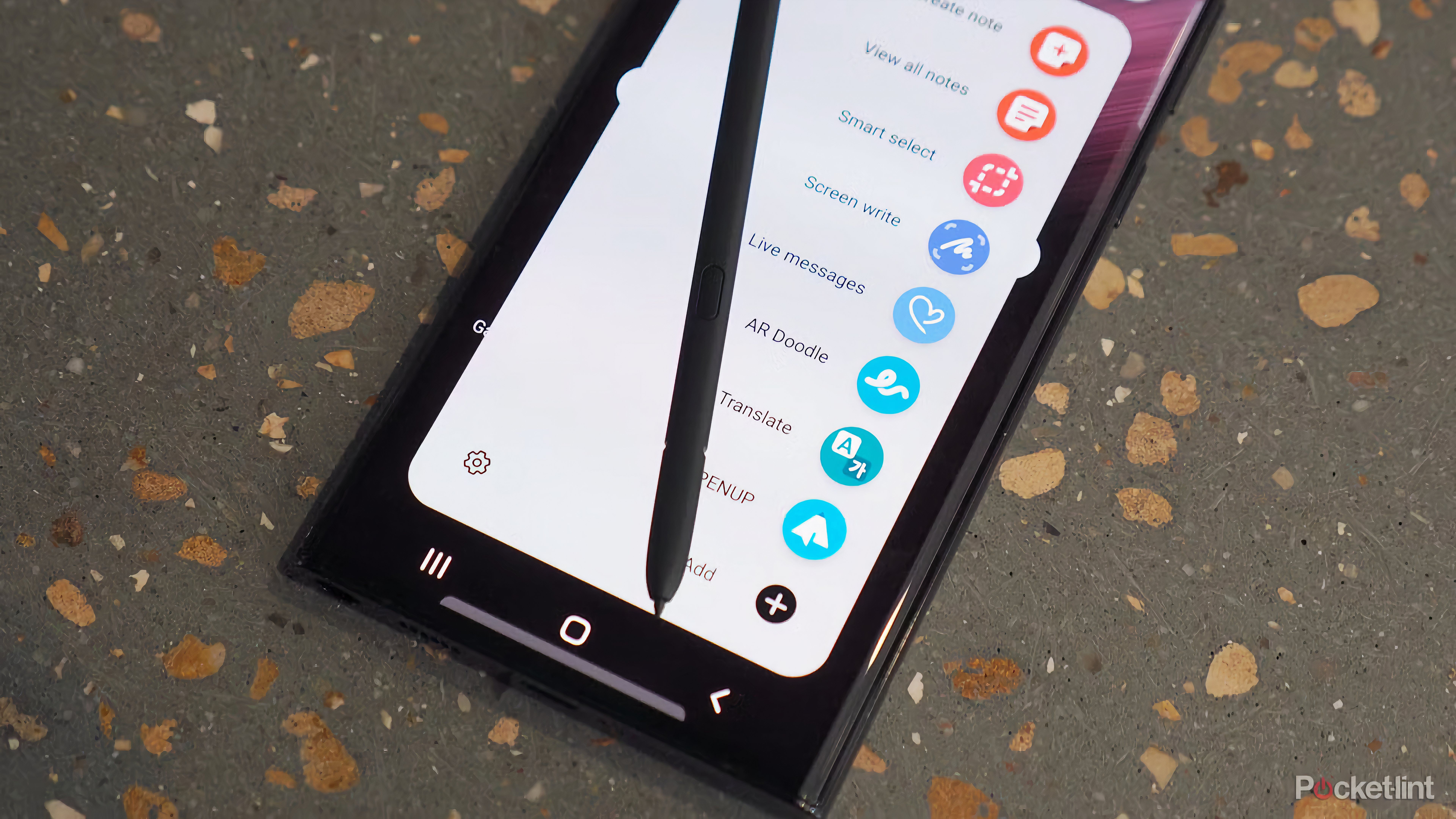 An S Pen laying on top of a Galaxy S22 Ultra.