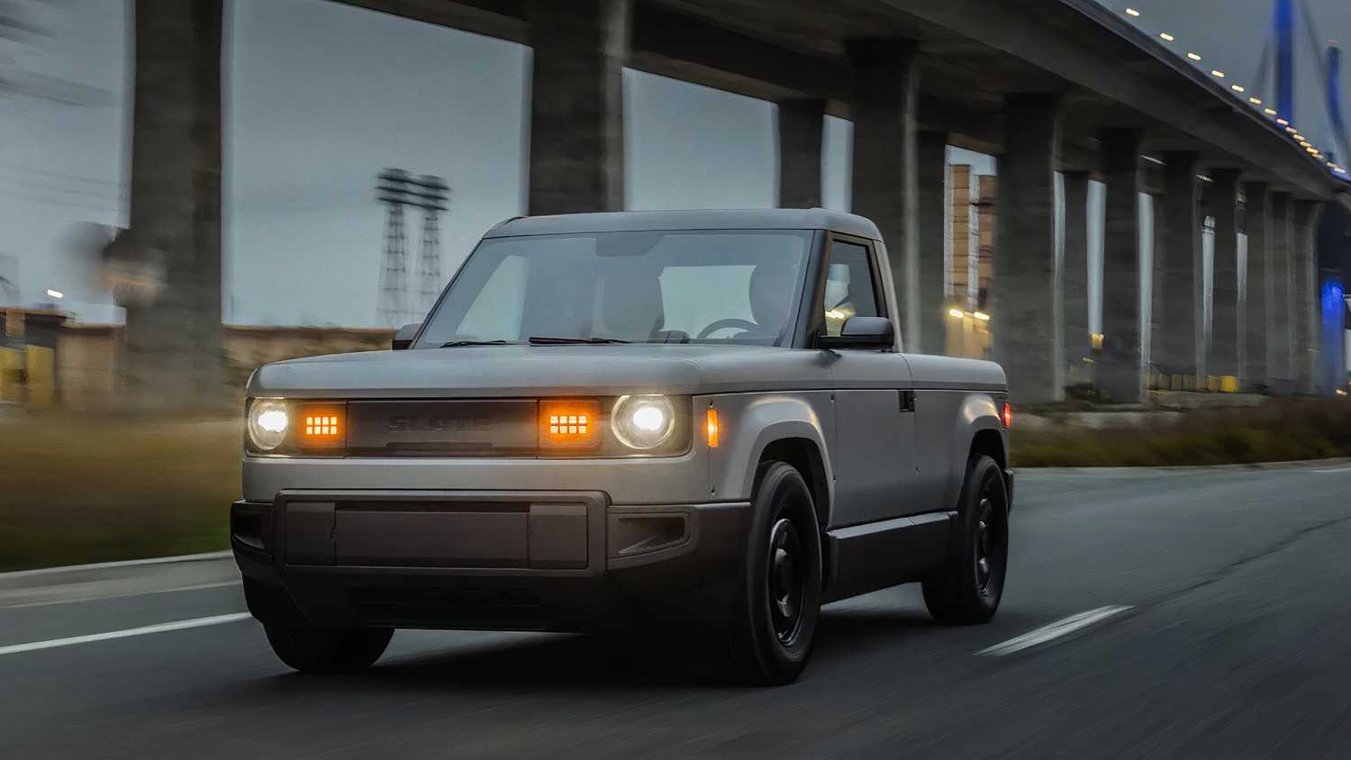 A still photo of the Slate truck driving on an overcast day. 