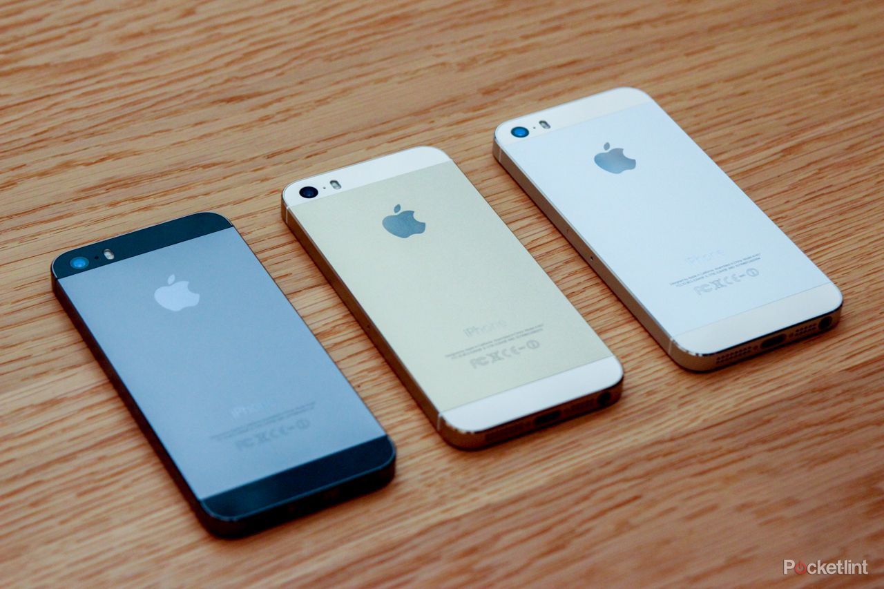 Three iPhone 5s handsets on a wooden table